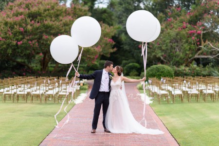 Bride and groom kissing holding large white balloons Pine Lakes Country Club