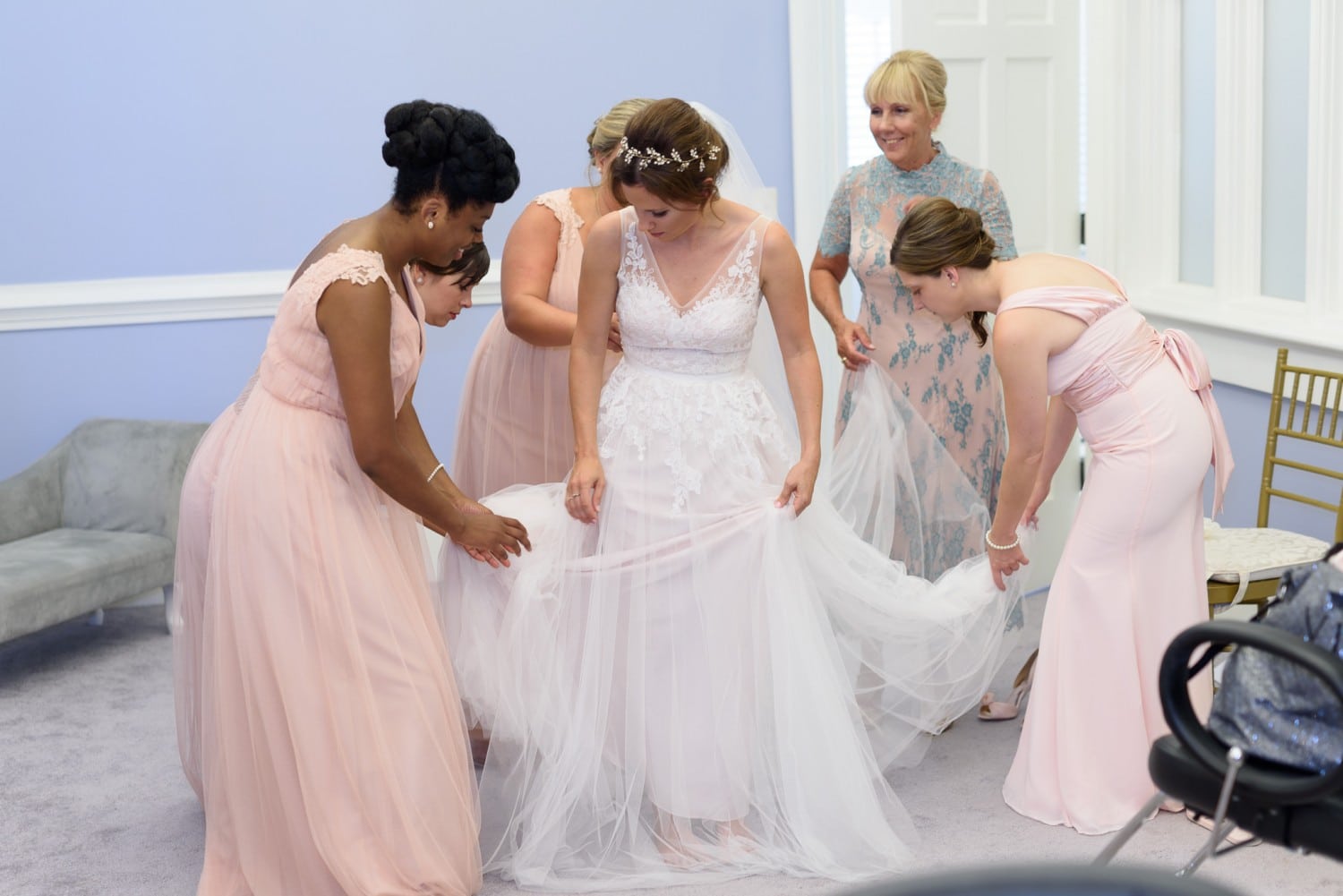 Bridesmaids helping bride with her dress Pine Lakes Country Club