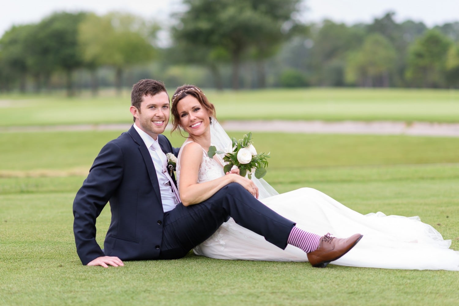 Couple laying together on the golf course Pine Lakes Country Club