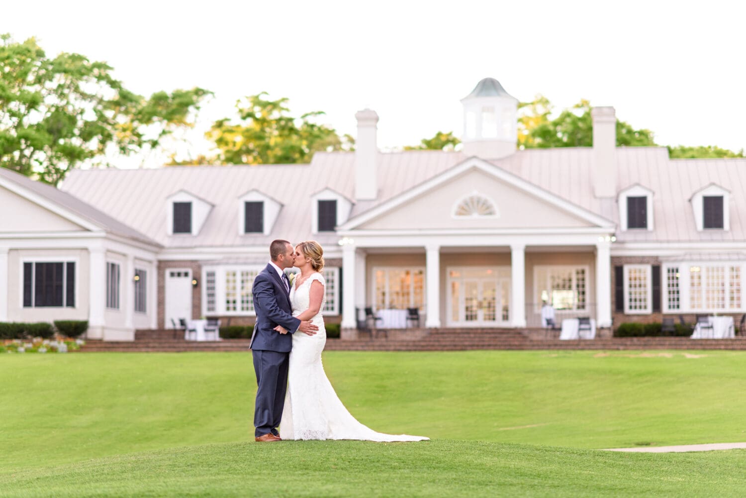 Bride and groom kissing behind the Pawleys Plantation Clubhouse - Pawleys Plantation Golf & Country Club