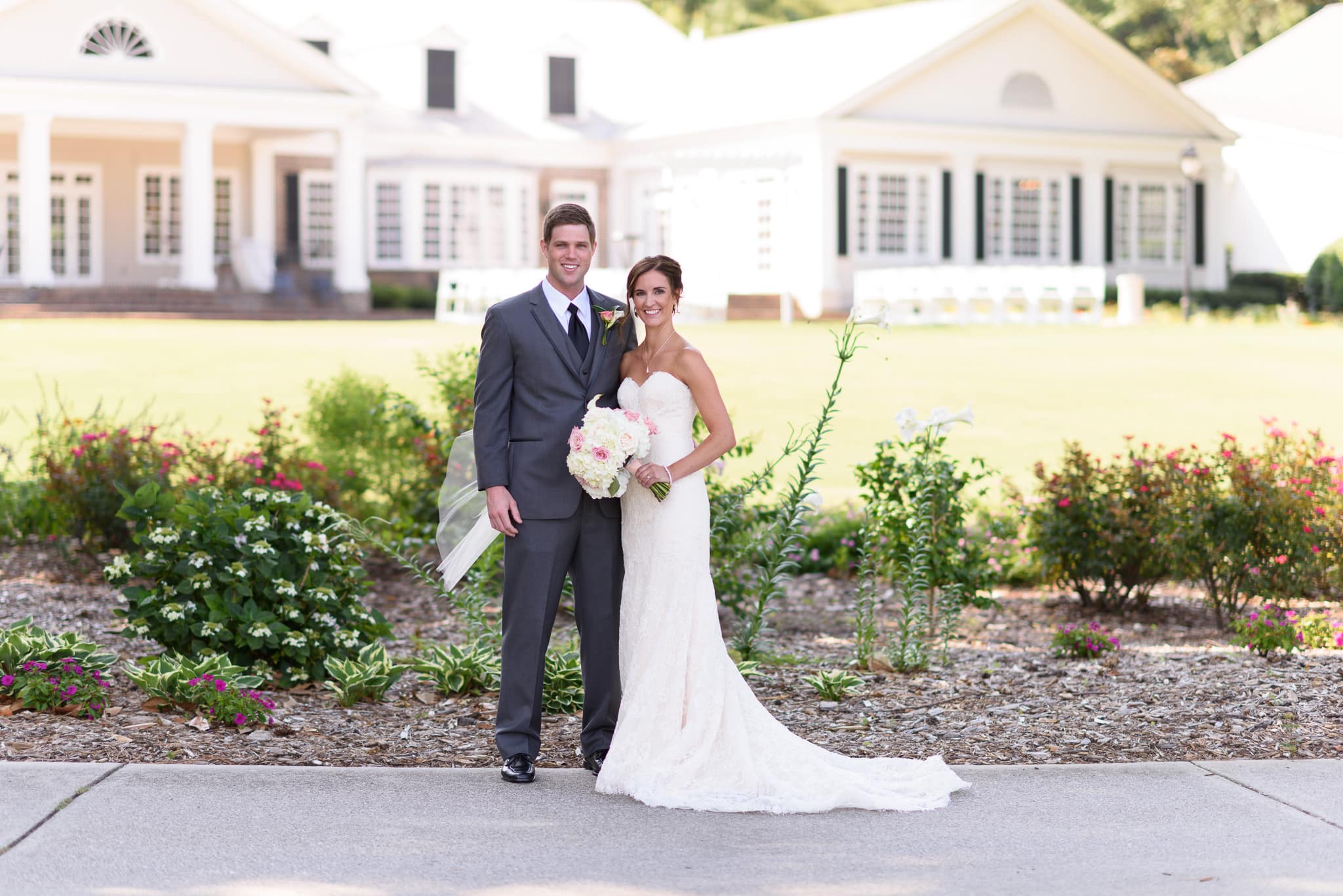 Bride and groom posing behind the country club - Pawleys Plantation