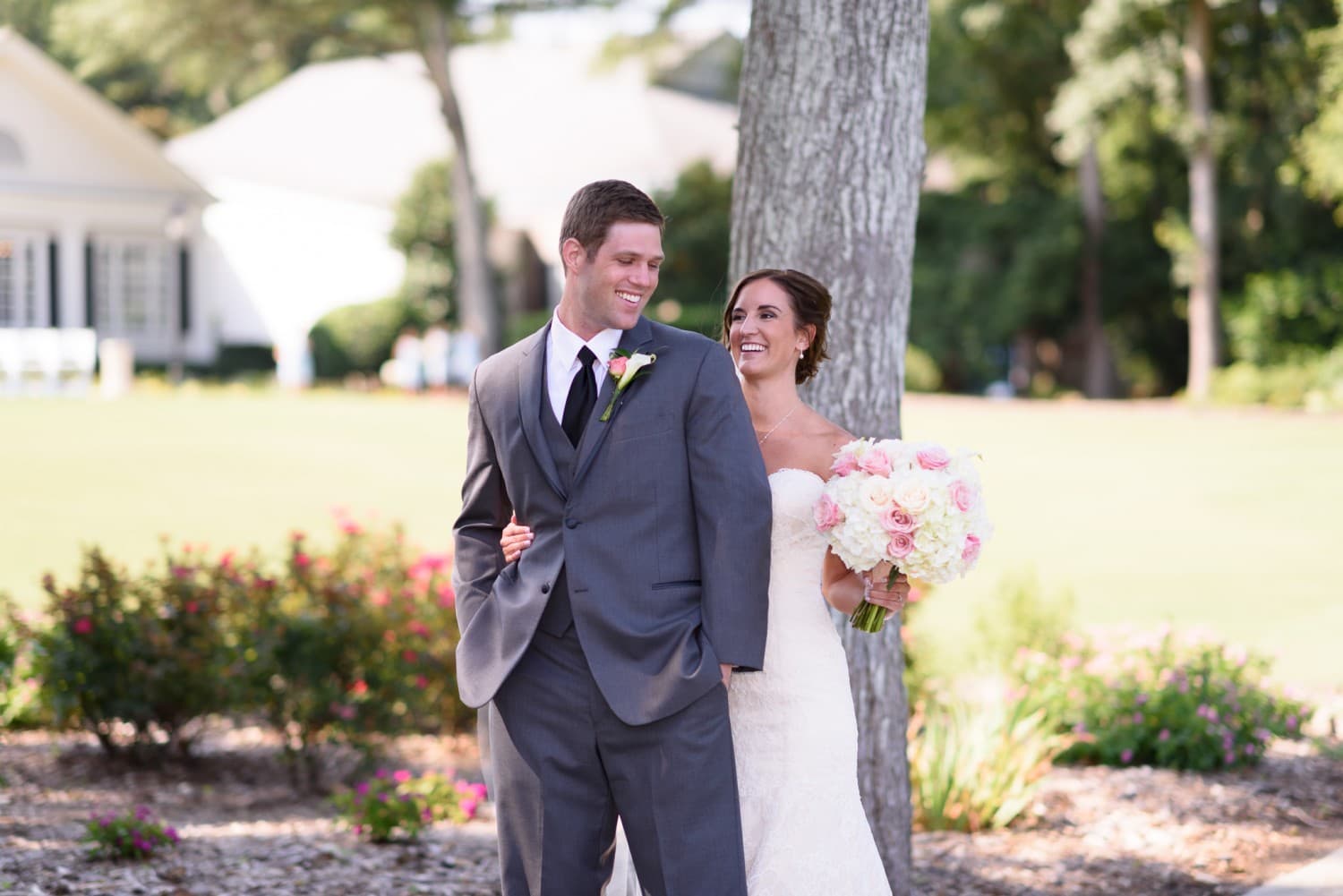 Bride putting arms around groom during first look - Pawleys Plantation