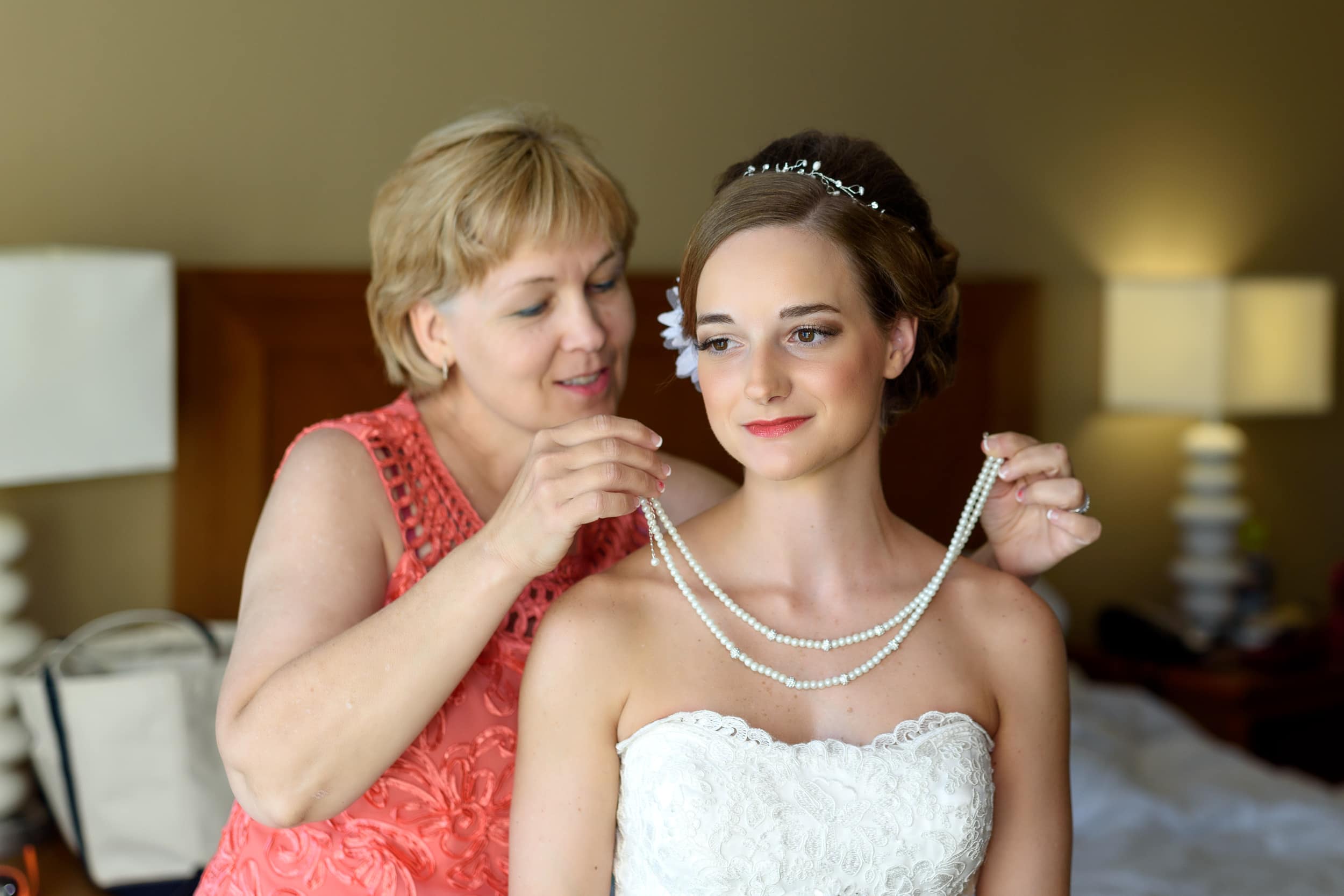 Bride's mom putting on her necklace before the ceremony  - Hilton at Kingston Plantation
