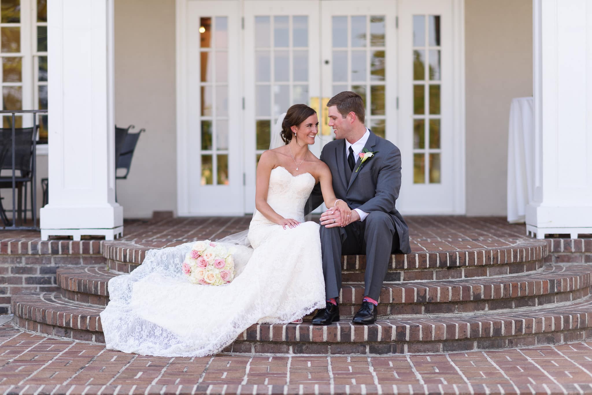 Couple sitting on back porch steps of clubhouse - Pawleys Plantation