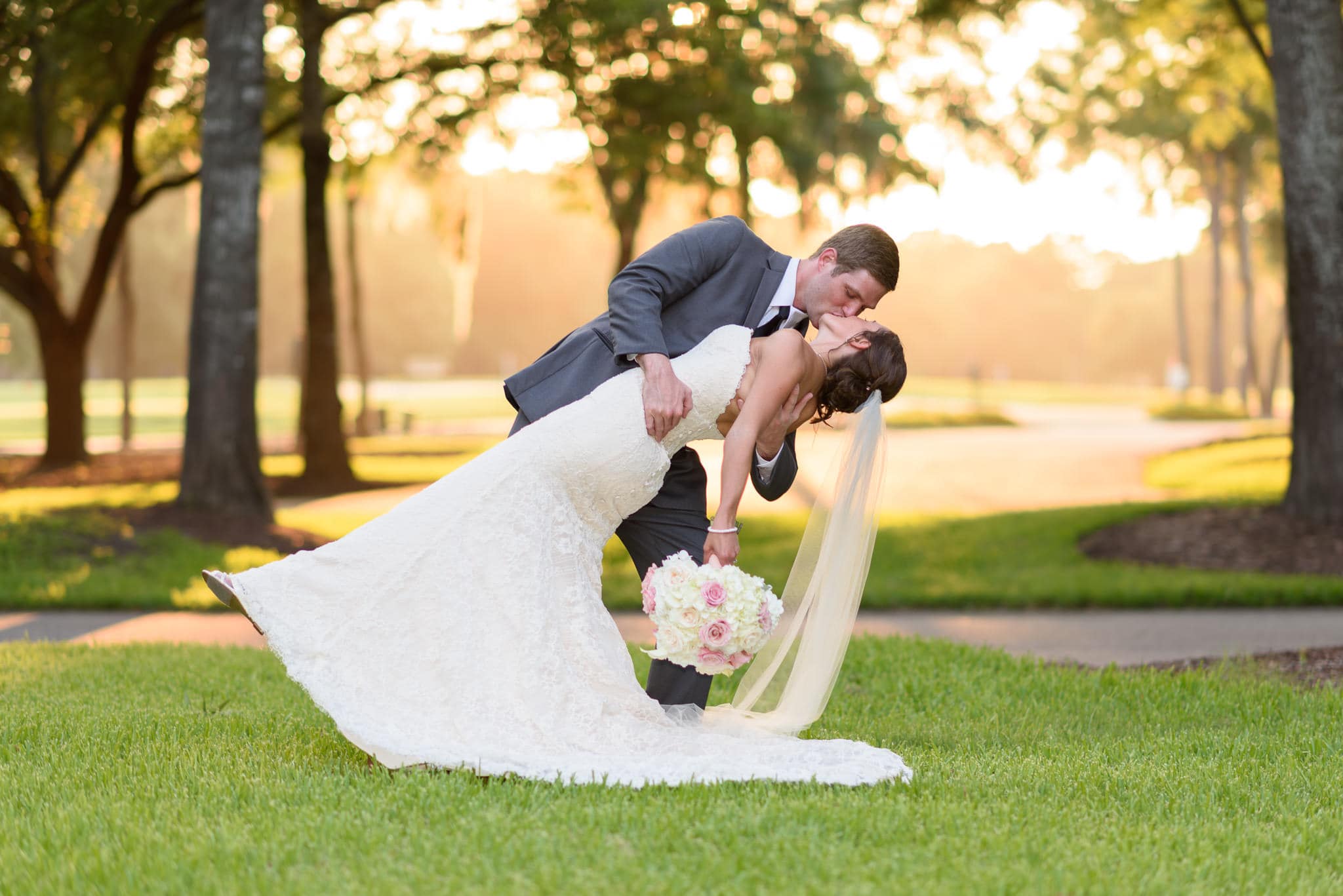 Dipping back bride for kiss backlit by sunset - Pawleys Plantation