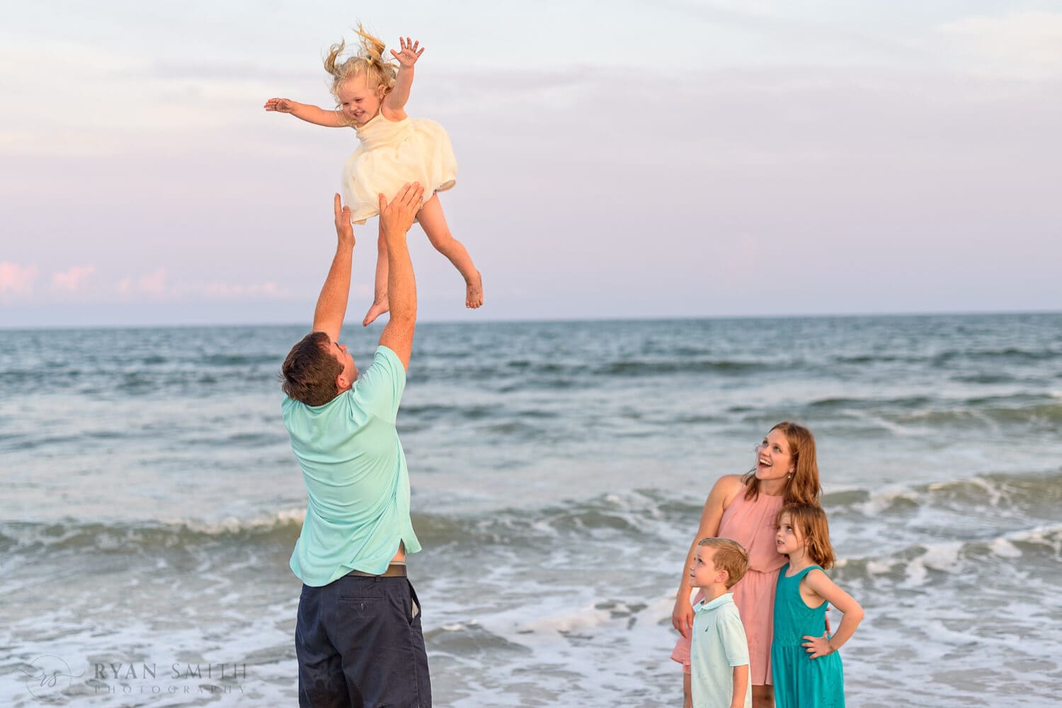 Family watching dad toss baby into the air - Murrells Inlet
