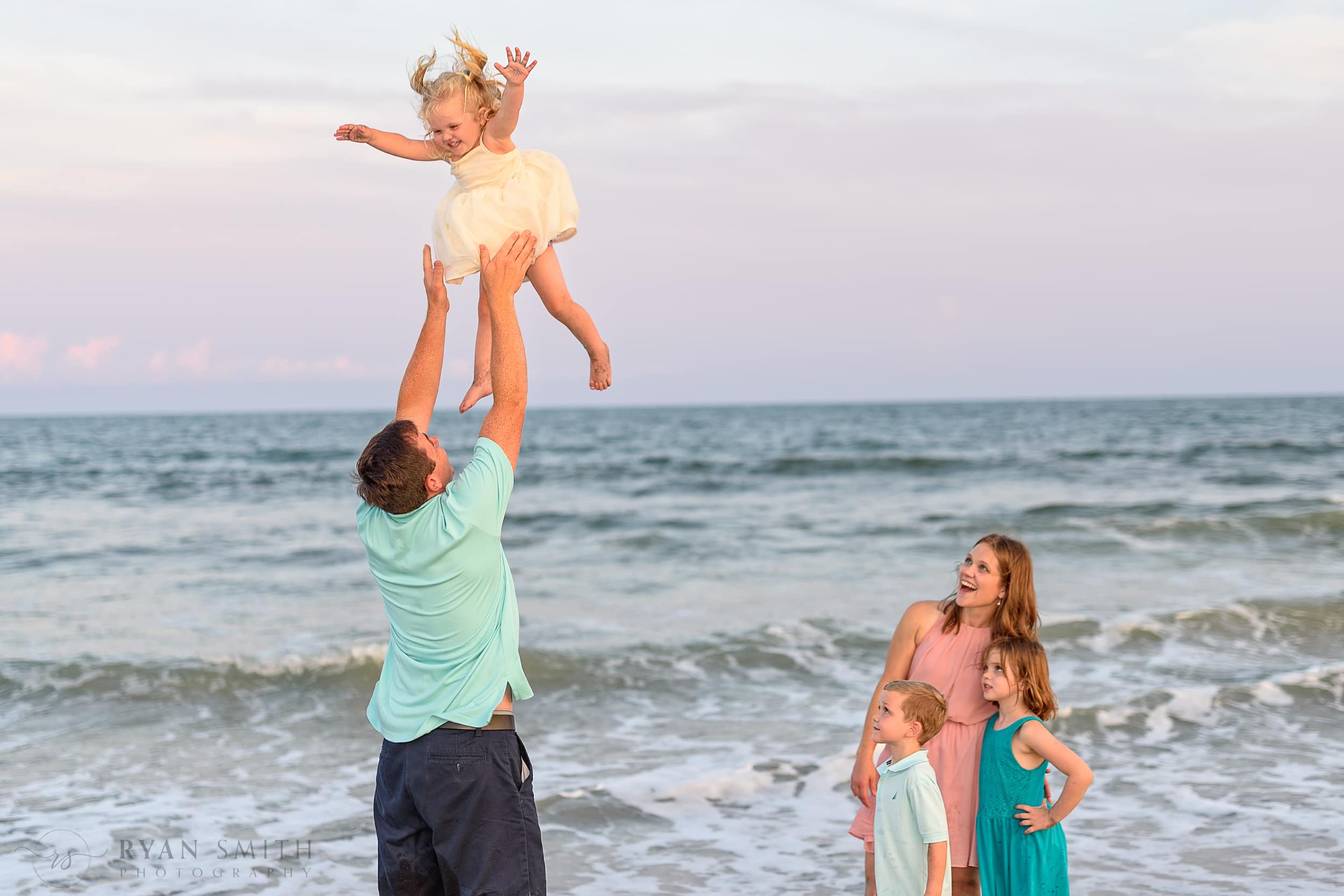 Family watching dad toss baby into the air - Murrells Inlet