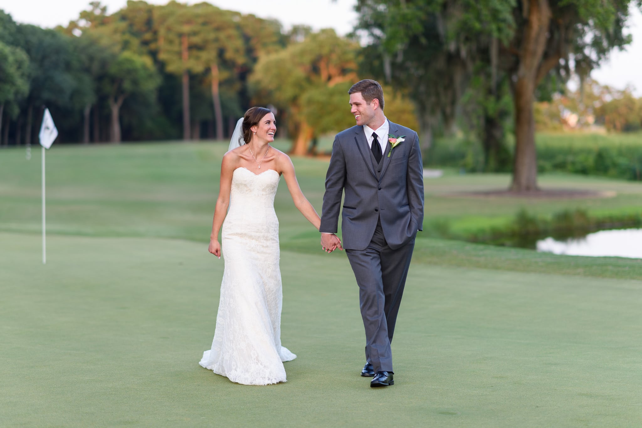Holding hands walking down golf course - Pawleys Plantation