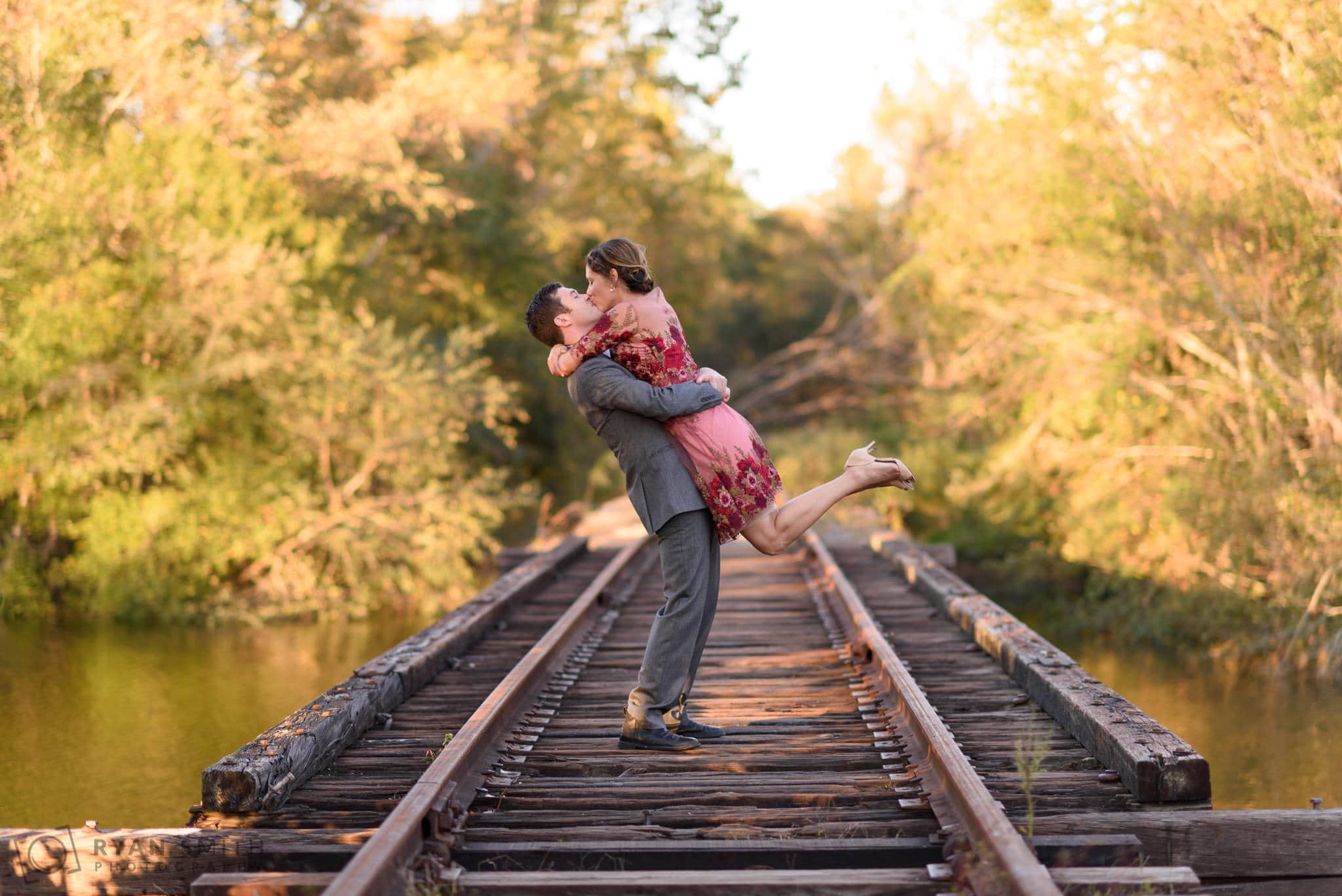 Lifting fiancé into the air on train tracks - Conway River Walk