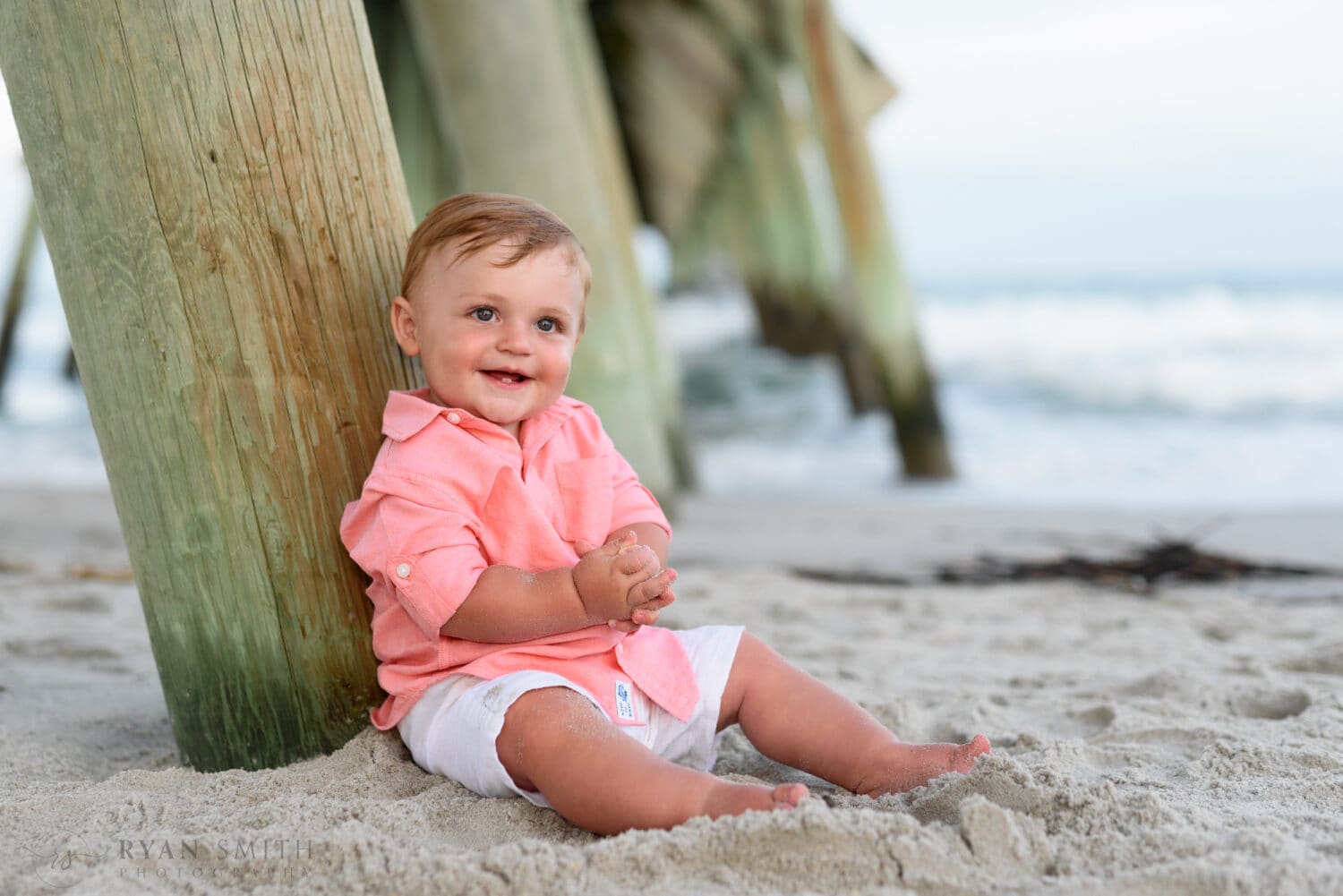 Really cute baby boy sitting by pier - Myrtle Beach State Park