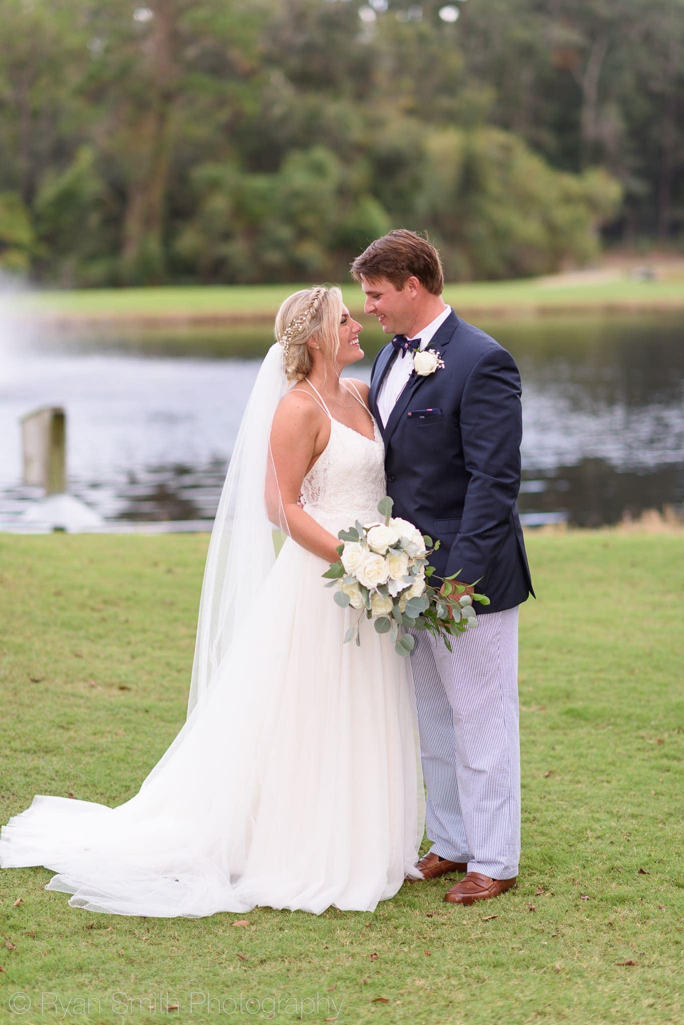 Bride and groom looking at each other by lake - Pawleys Plantation