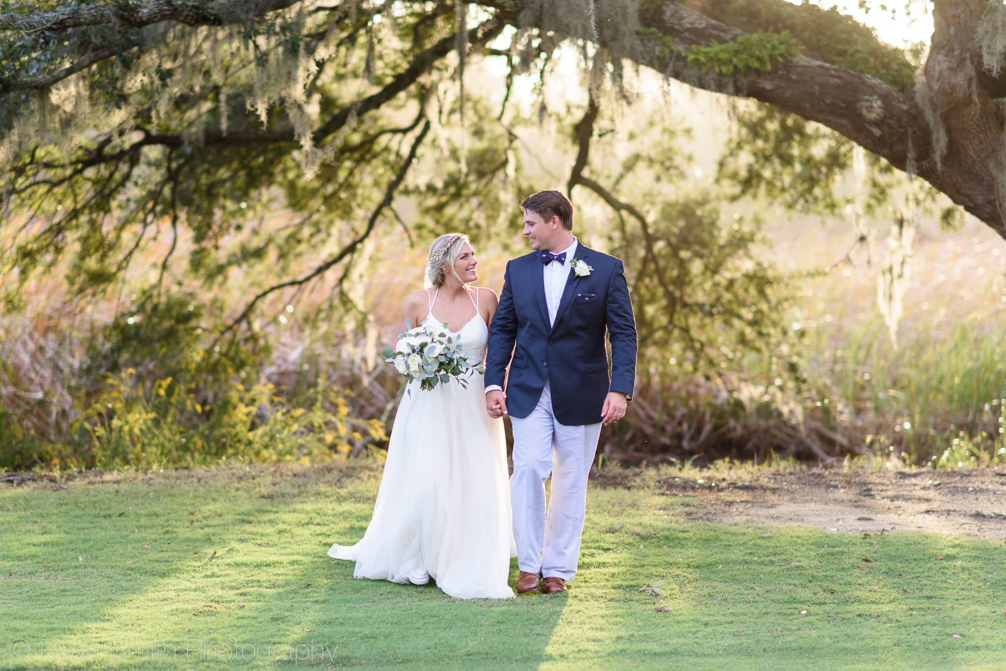 Bride and groom walking together in the sunset - Pawleys Plantation