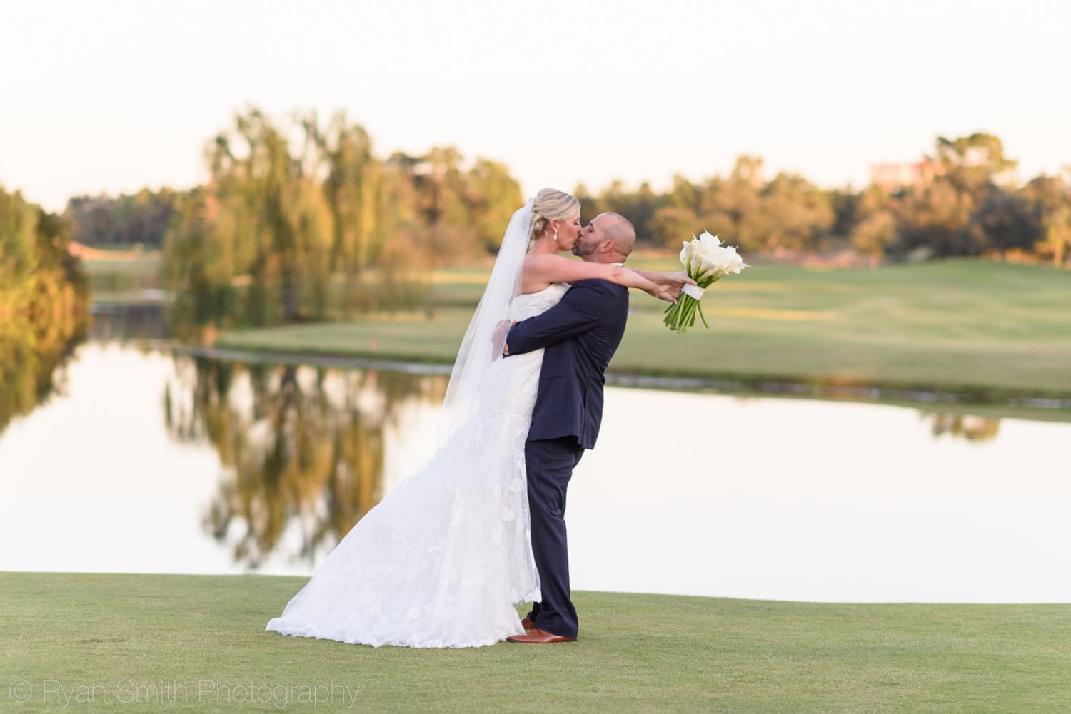 Groom lifting bride into the air for a kiss - Members Club - Grande Dunes