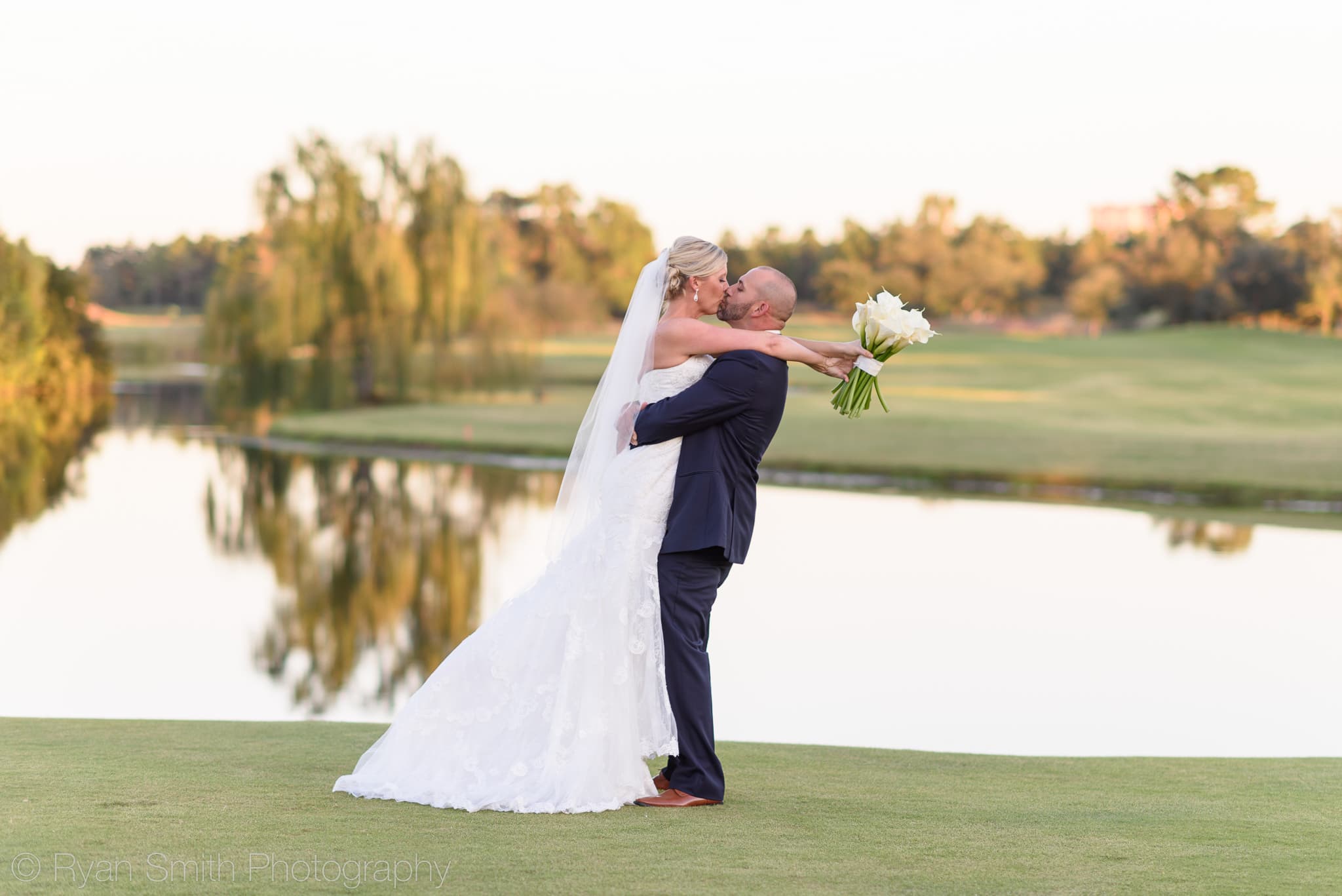 Groom lifting bride into the air for a kiss - Members Club - Grande Dunes