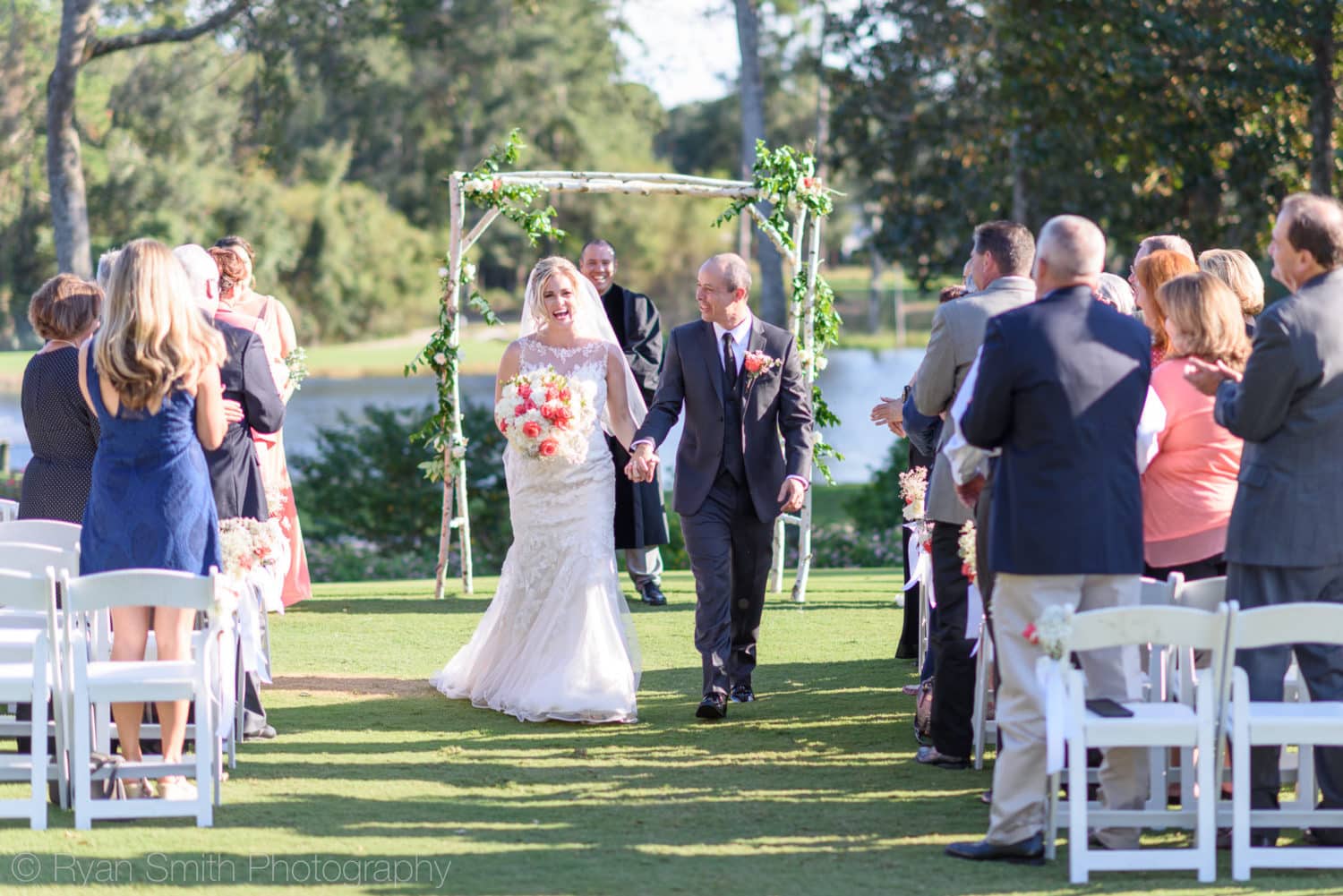 Happy couple walking down the isle after ceremony - Pawleys Plantation