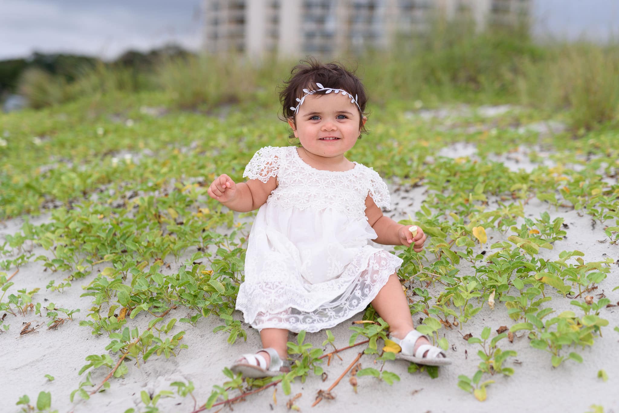 Baby girl smiling for the camera by dunes - North Beach Plantation