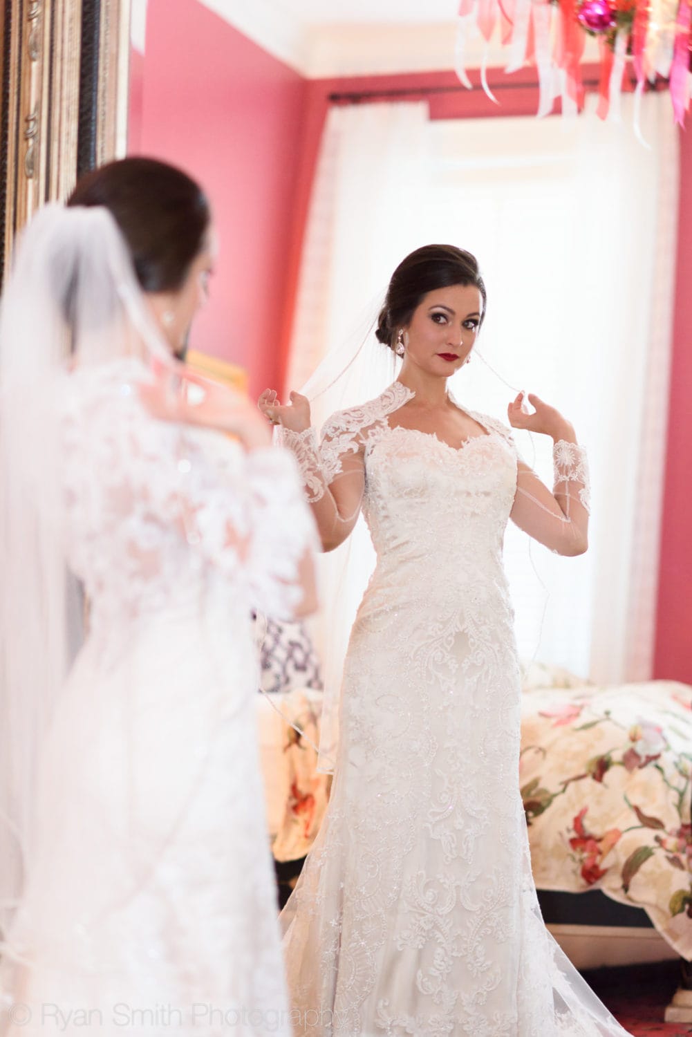 Bride adjusting her veil in the mirror - Rosewood Manor, Marion