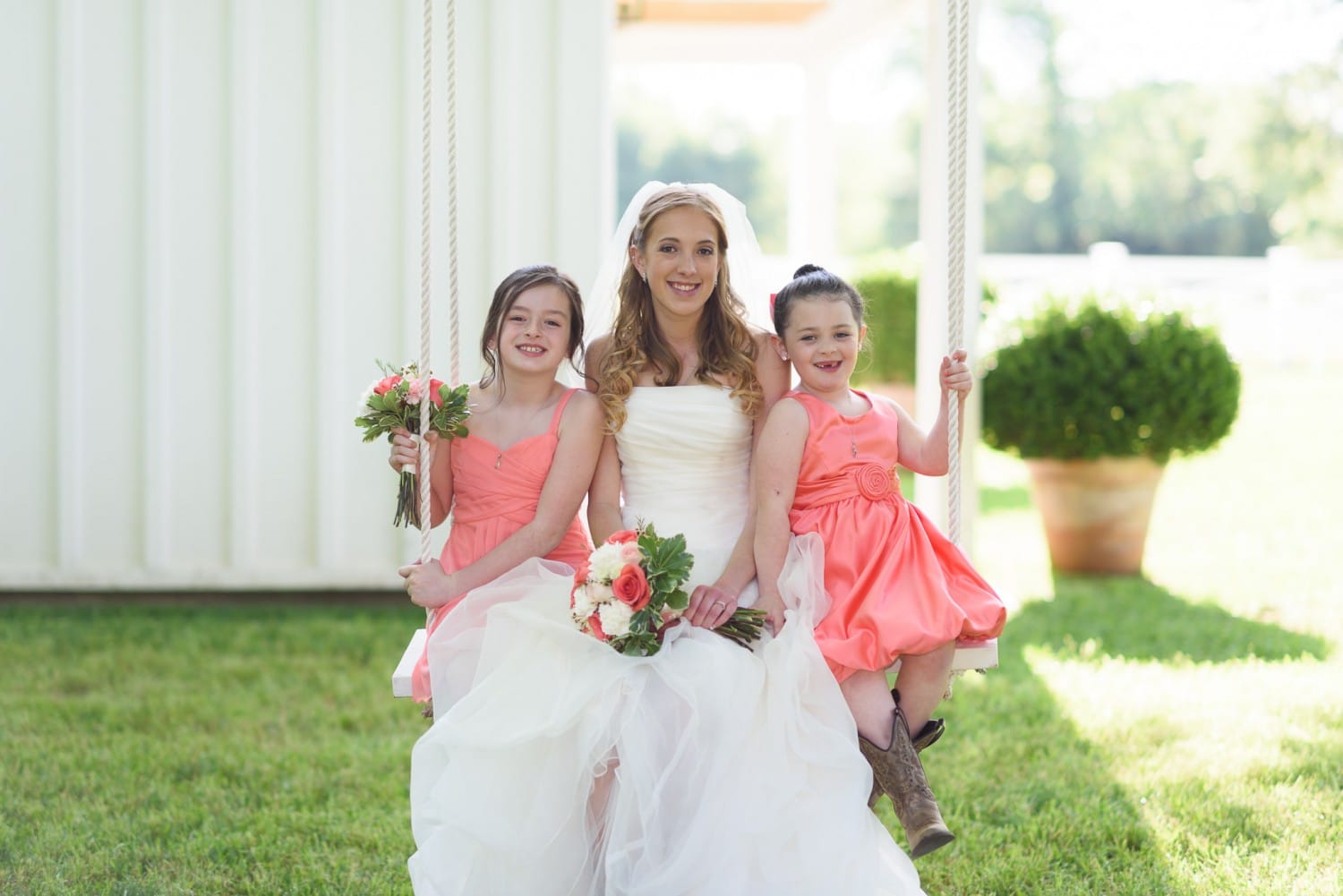 Bride and flower girls sitting on a swing - Wildberry Farm