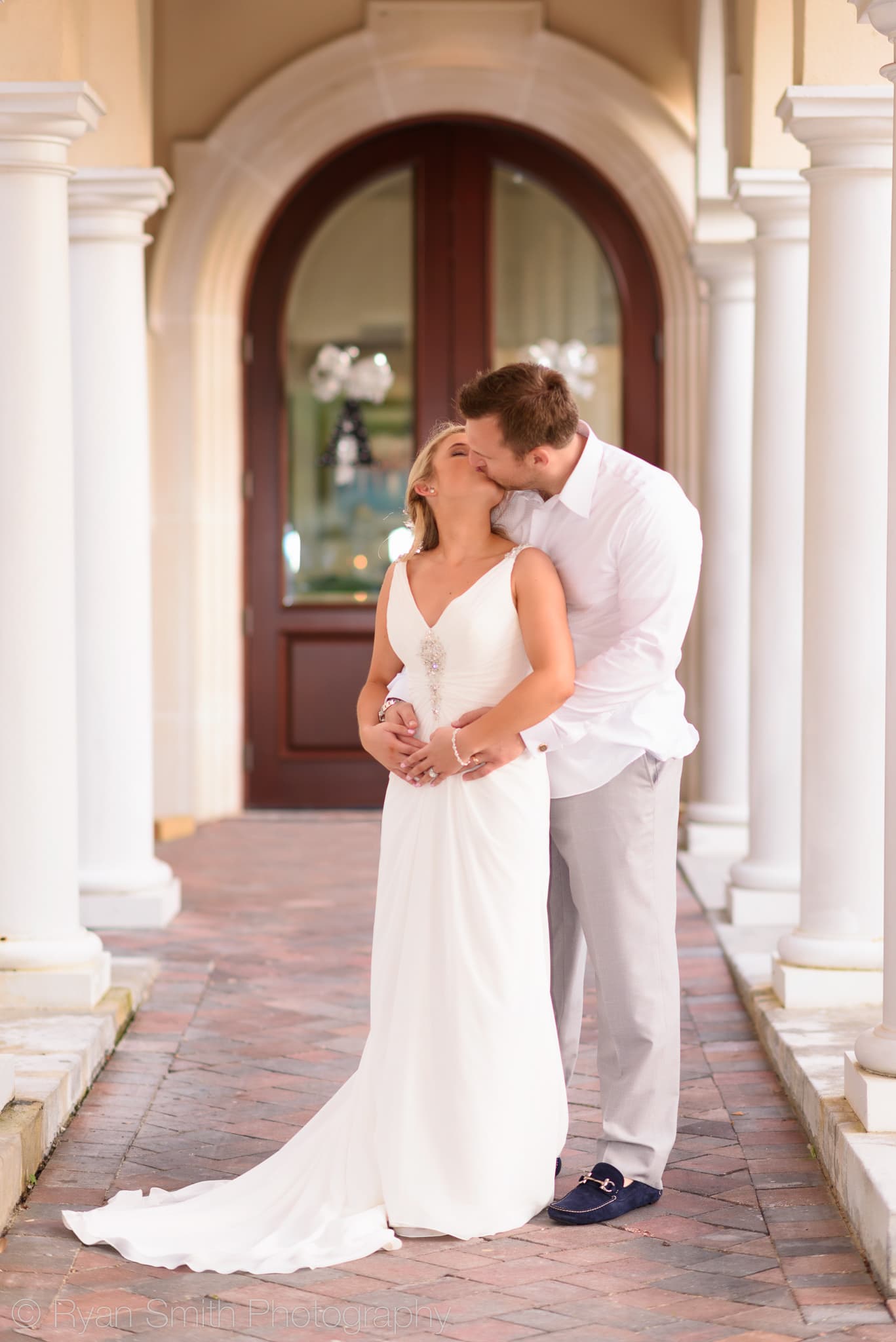 Bride and groom by clubhouse columns  - Grande Dunes Ocean Club
