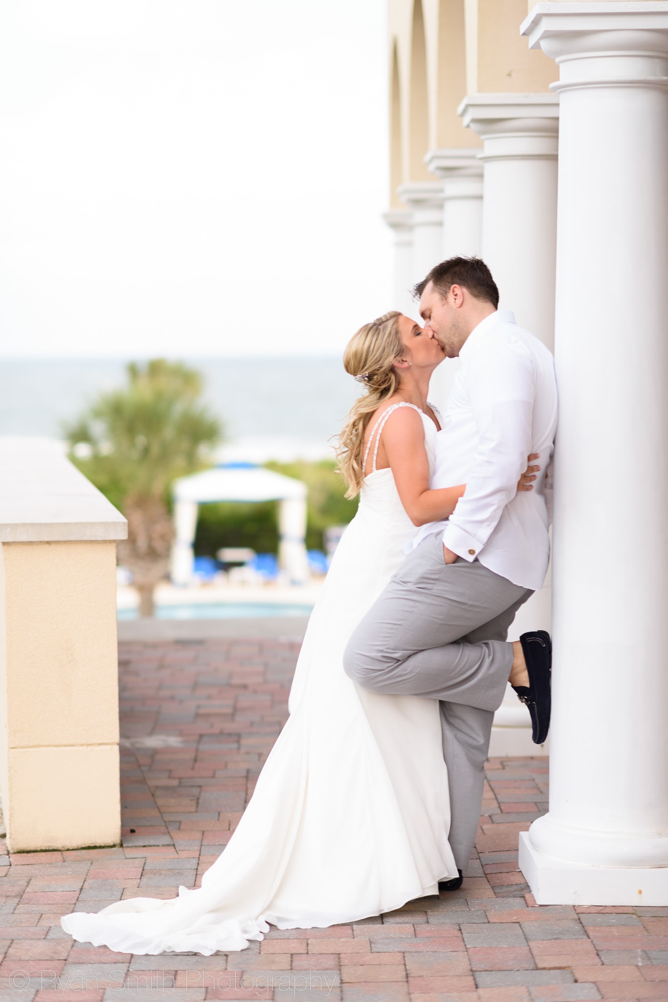 Bride and groom by clubhouse columns  - Grande Dunes Ocean Club