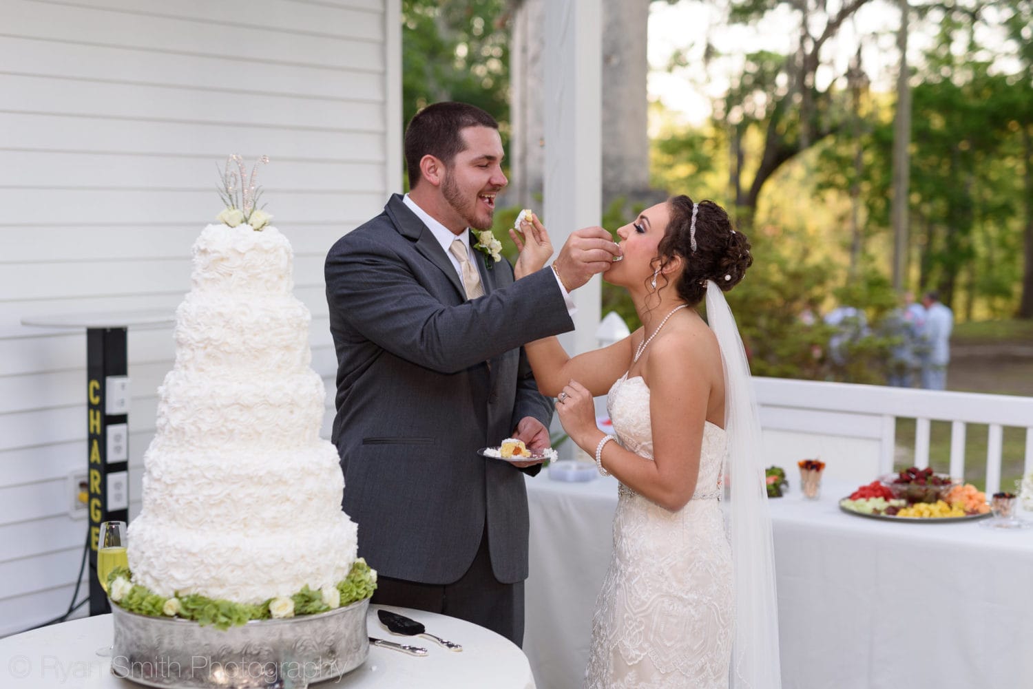 Bride and groom feeding each other wedding cake - Upper Mill Plantation