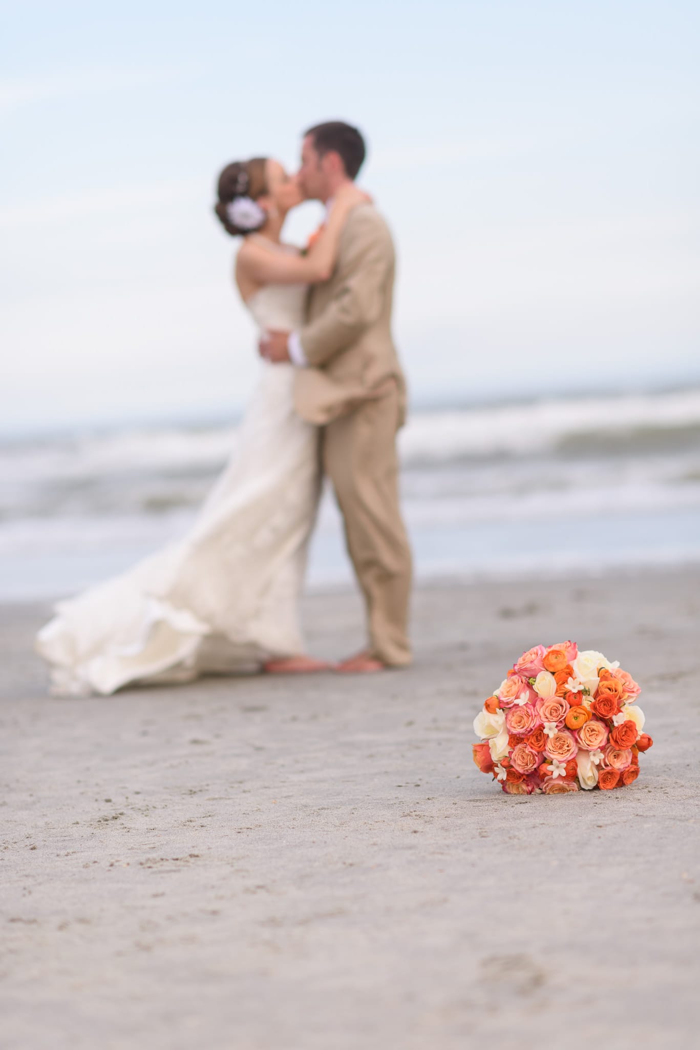 Bride and groom in background with bouquet in focus - Hilton at Kingston Plantation