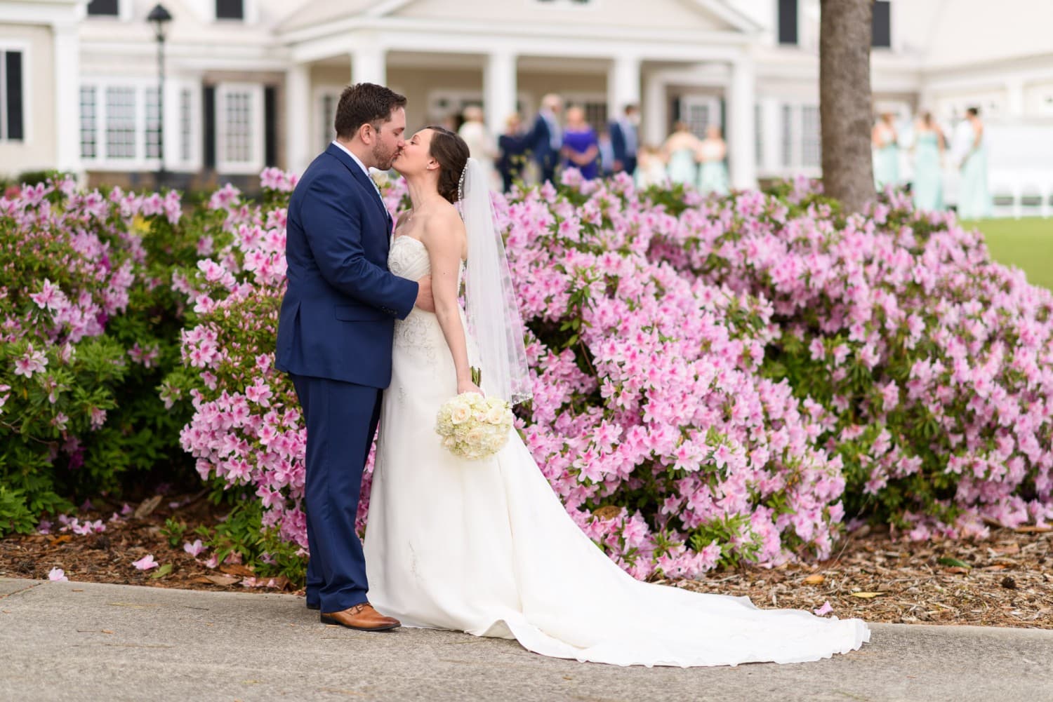 Bride and groom kissing by flowers - Pawleys Plantation