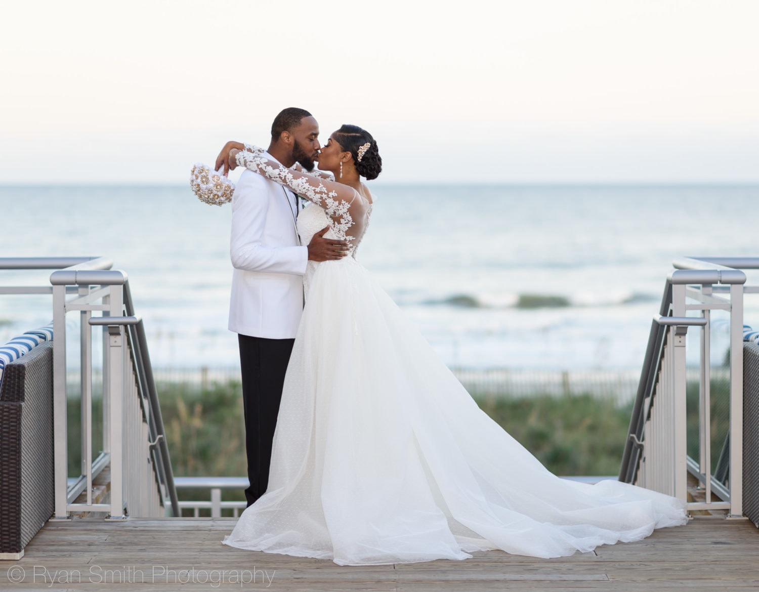 Bride and groom kissing in front of ocean - Doubletree Resort by Hilton Myrtle Beach