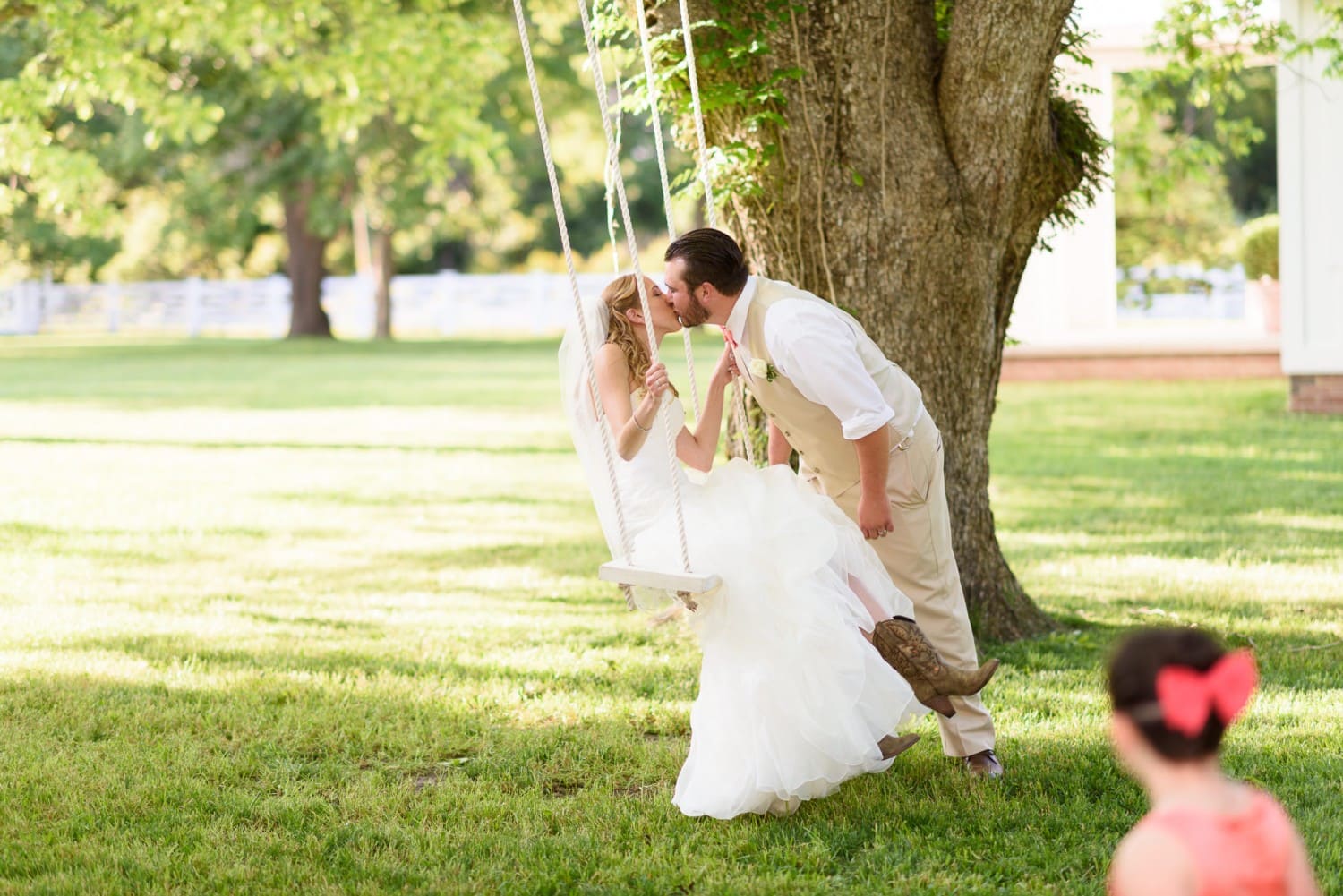 Bride and groom kissing on a swing - Wildberry Farm
