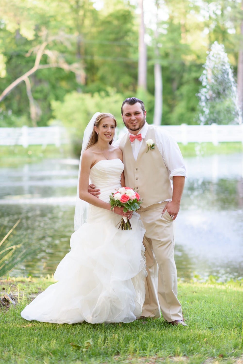 Bride and groom posing in front of the lake - Wildberry Farm