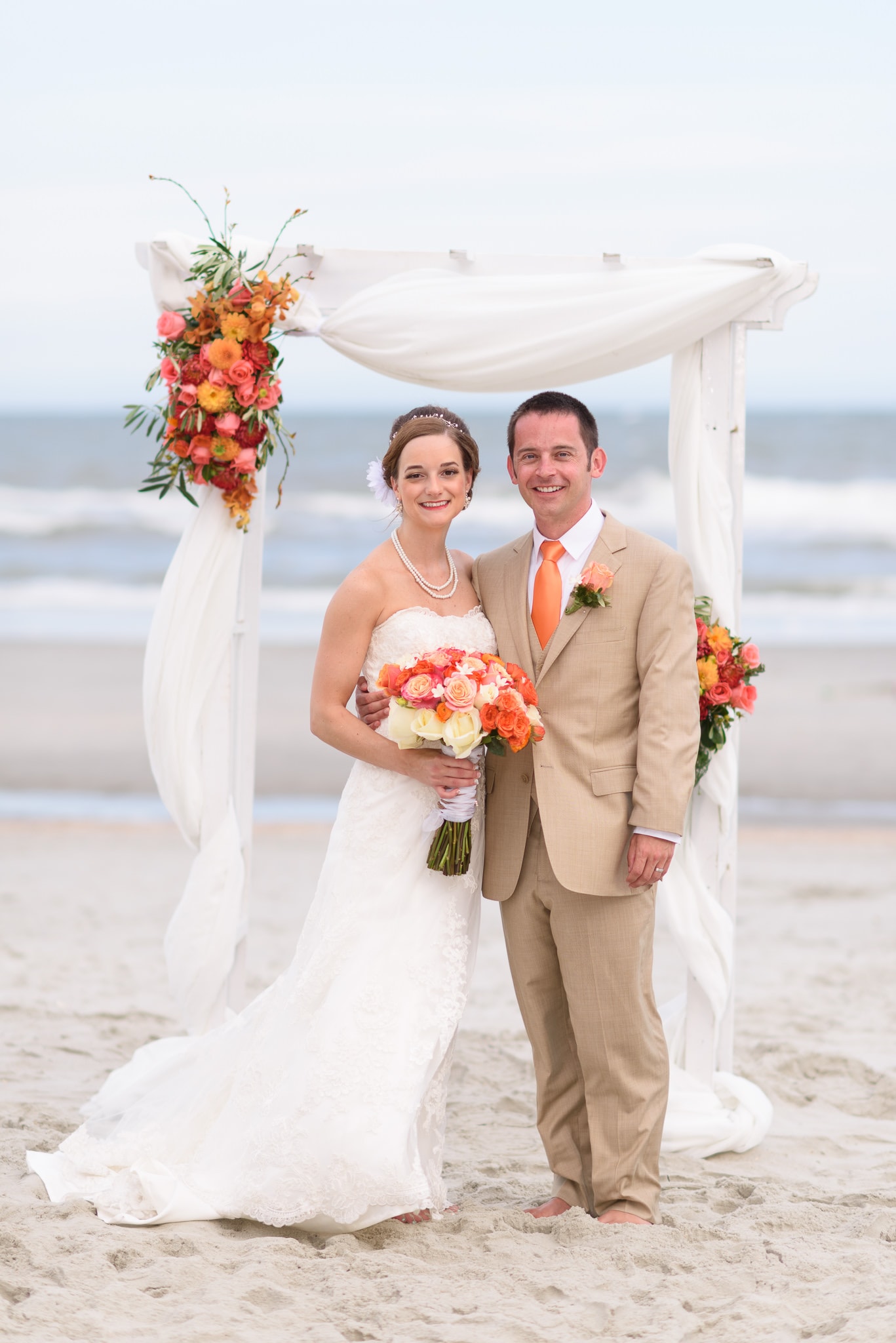 Bride and groom standing in front of beach wedding arbor - Hilton at Kingston Plantation