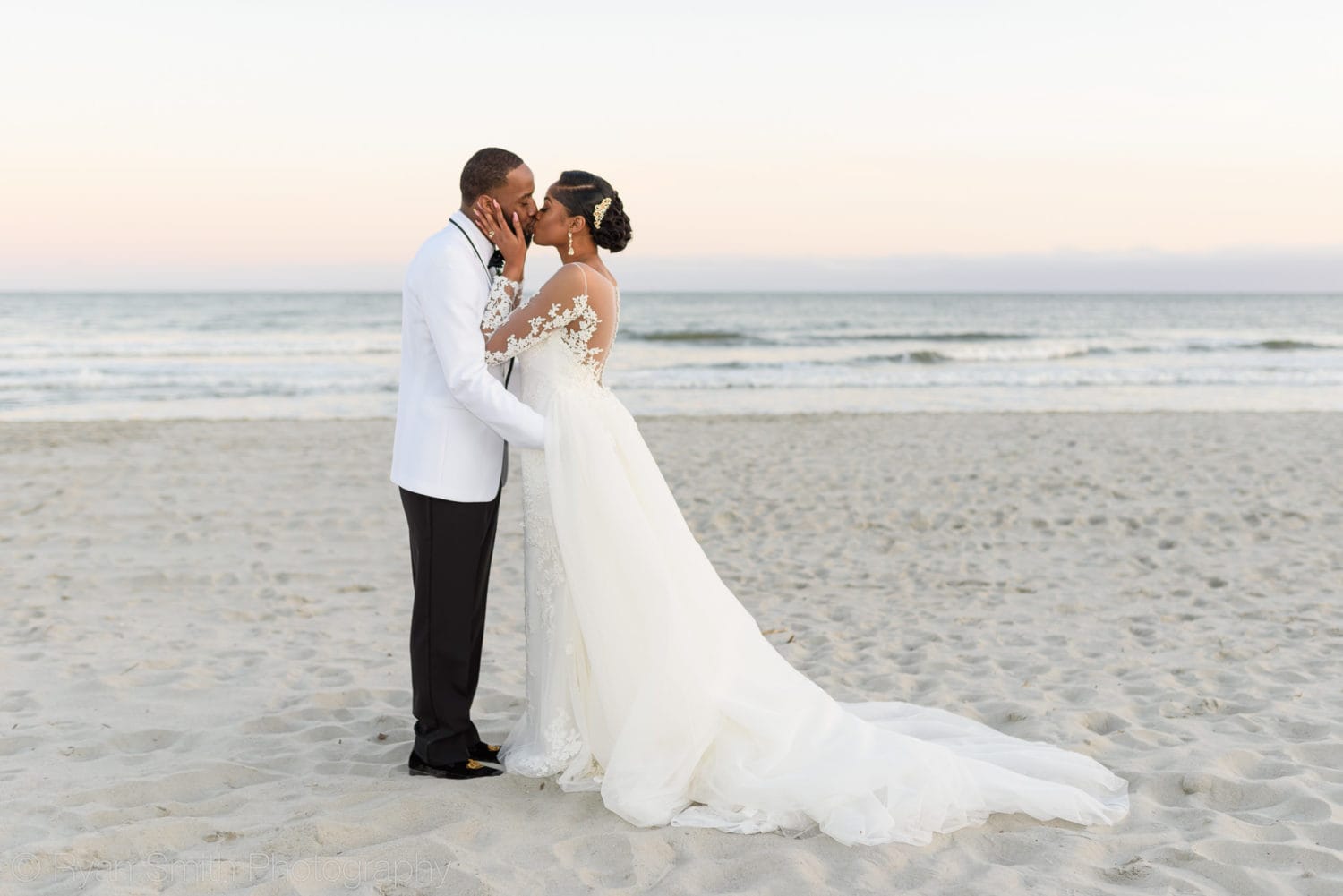 Bride kissing groom with hands on his cheeks  - Doubletree Resort by Hilton Myrtle Beach