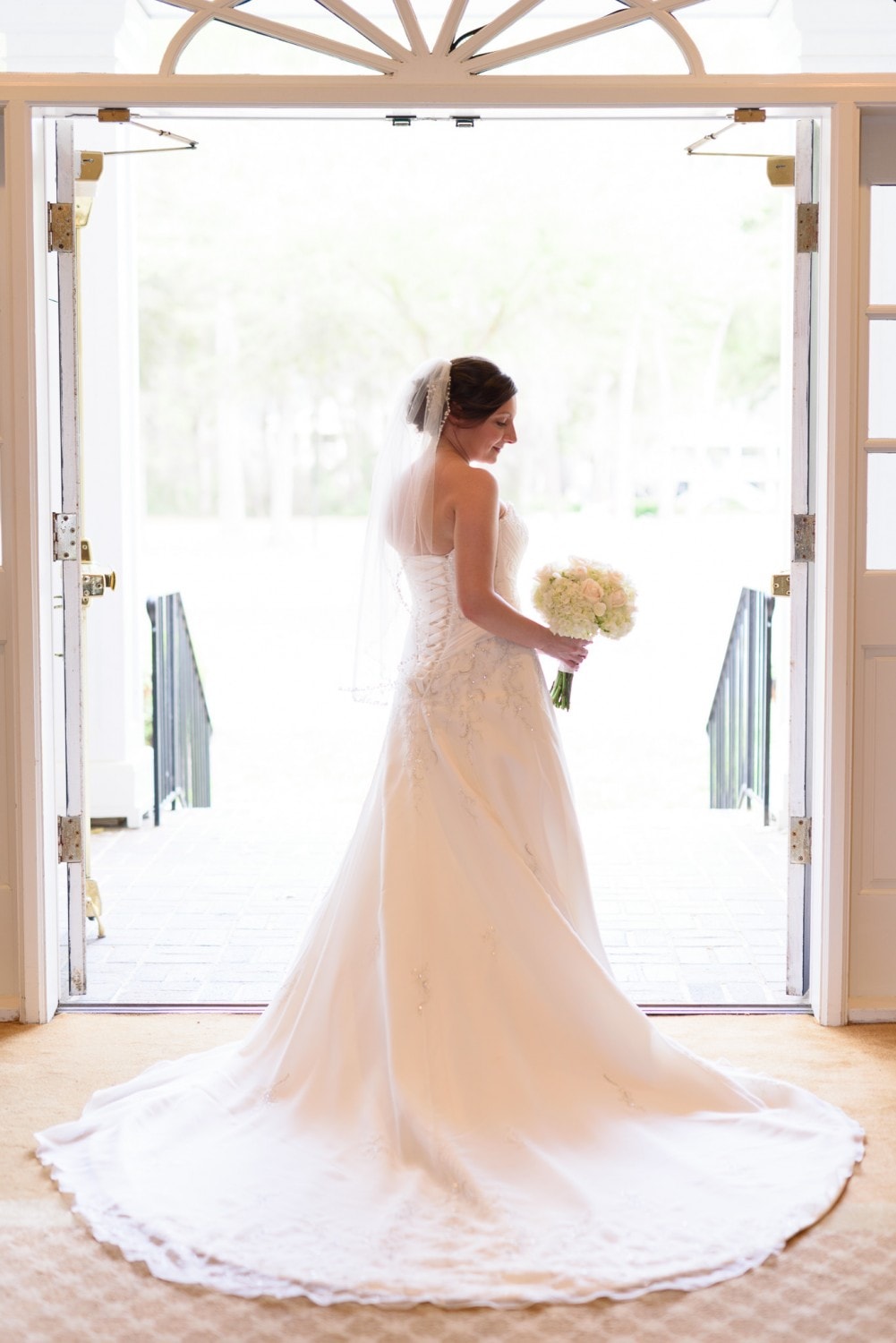 Bride posing in the sunlight from the doorway - Pawleys Plantation