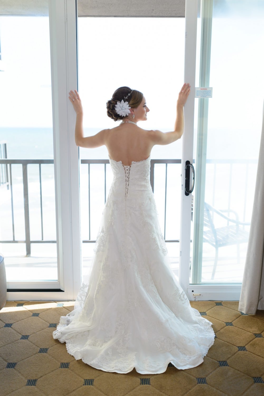Bride standing in balcony doorway - Hilton at Kingston Plantation