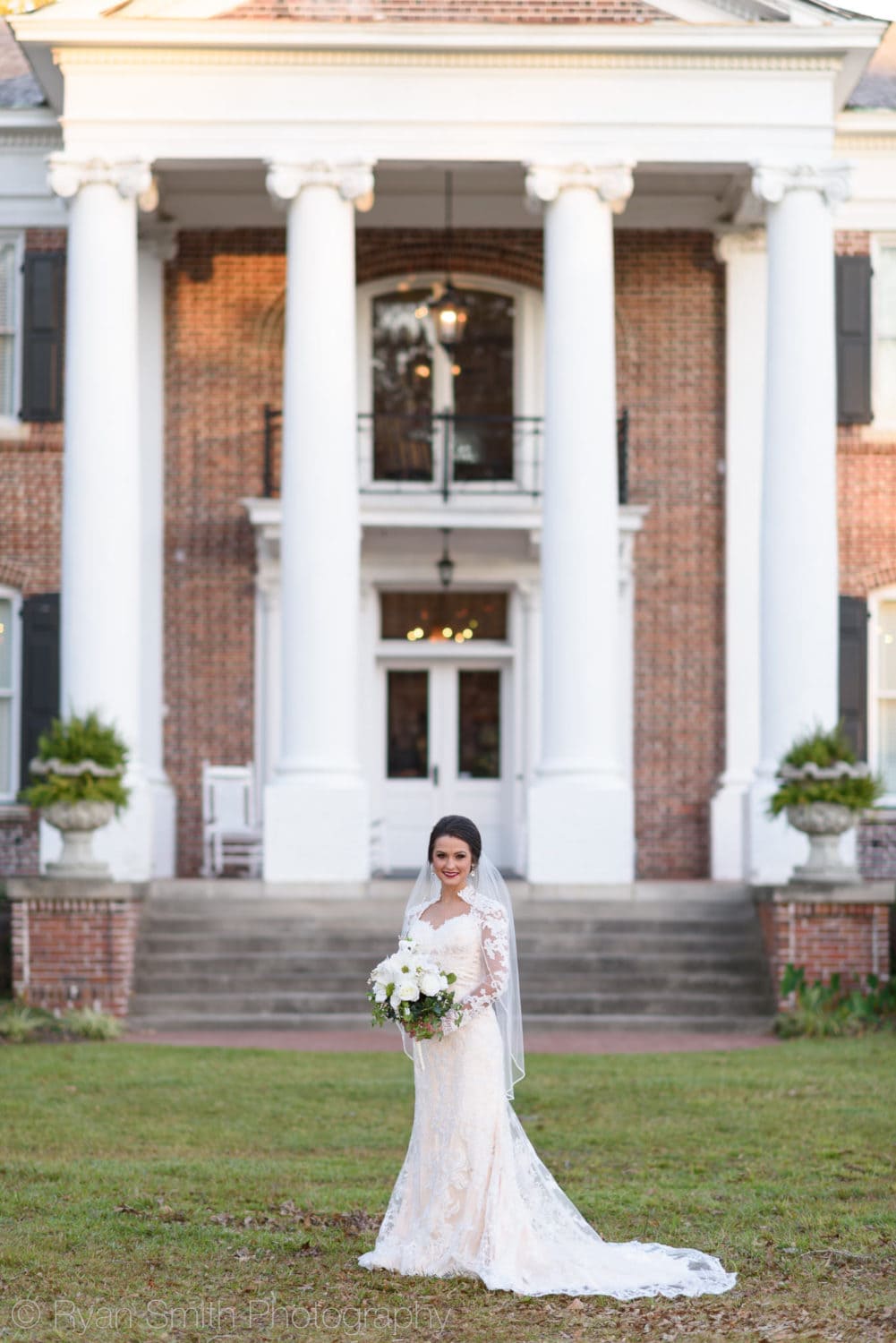 Bride standing in front of entryway columns - Rosewood Manor - Marion - Rosewood Manor, Marion