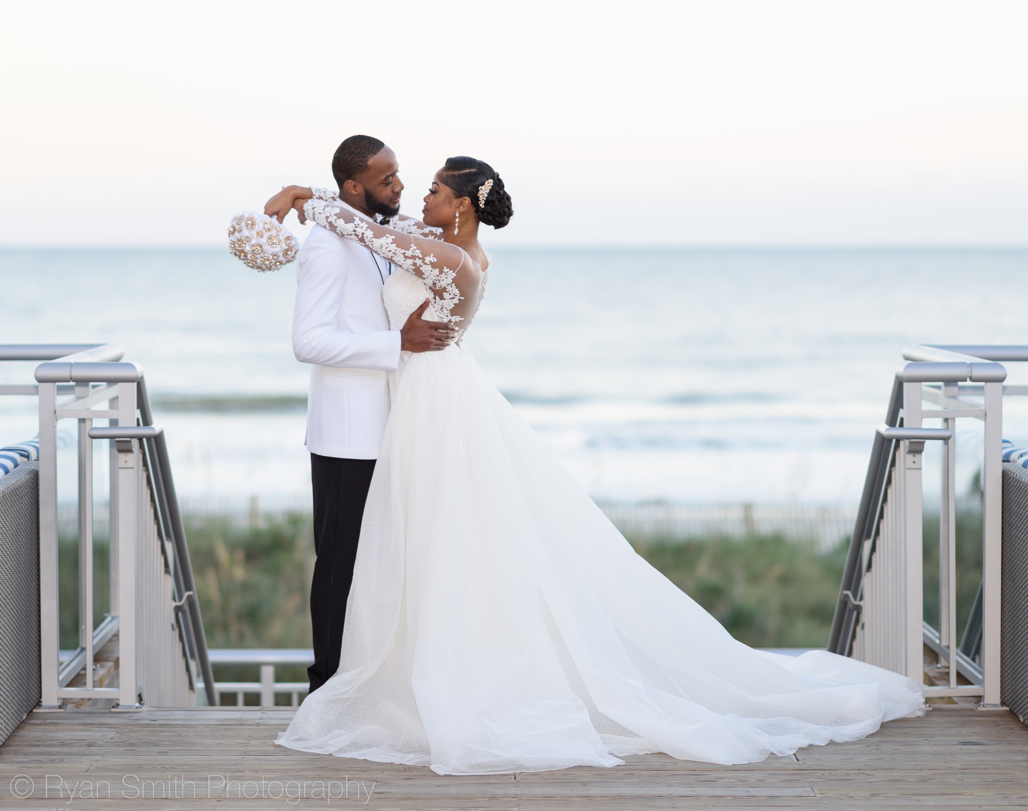 Bride with arms around groom in front of ocean - Doubletree Resort by Hilton Myrtle Beach