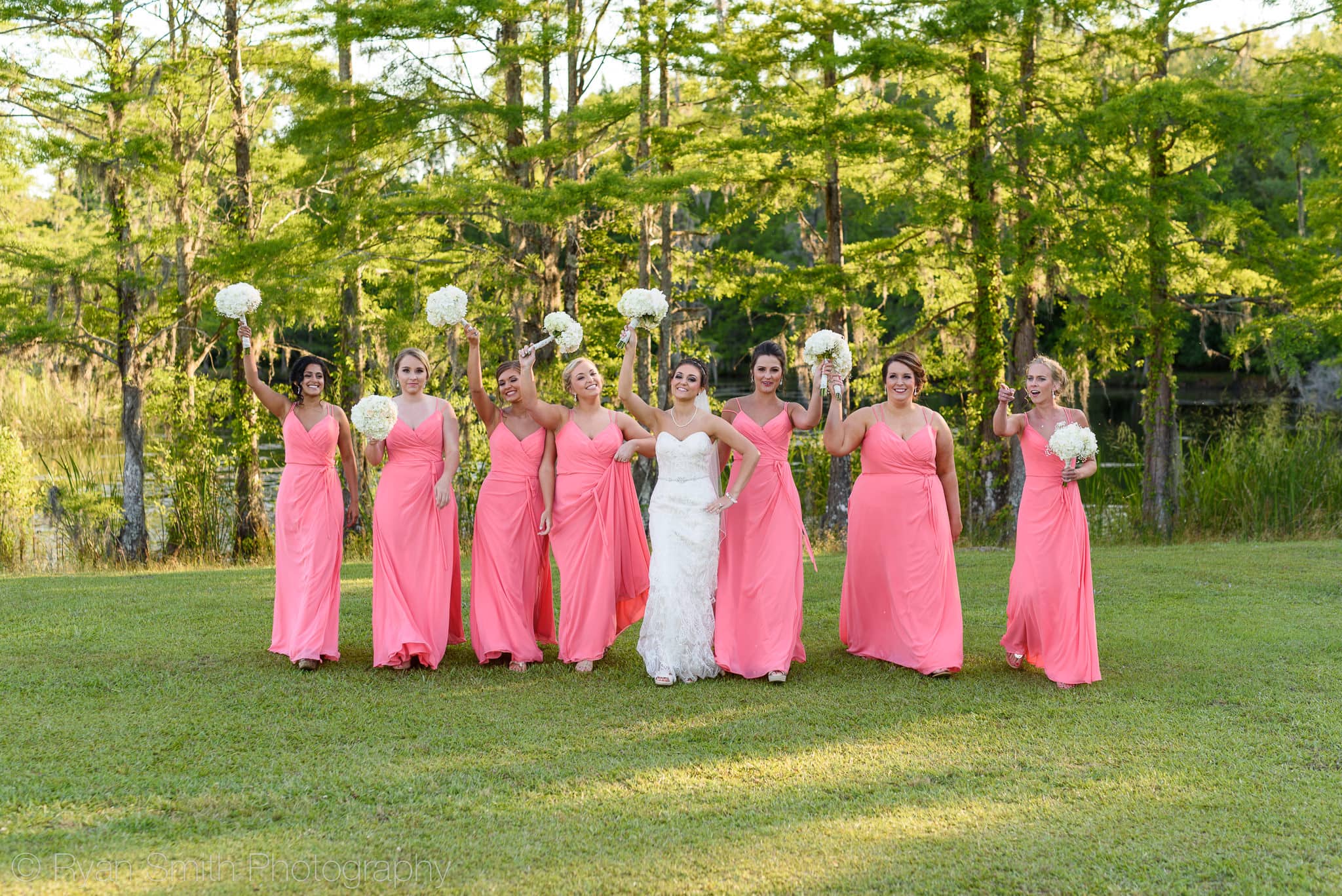 Bridesmaids having fun holding flowers in the air - Upper Mill Plantation