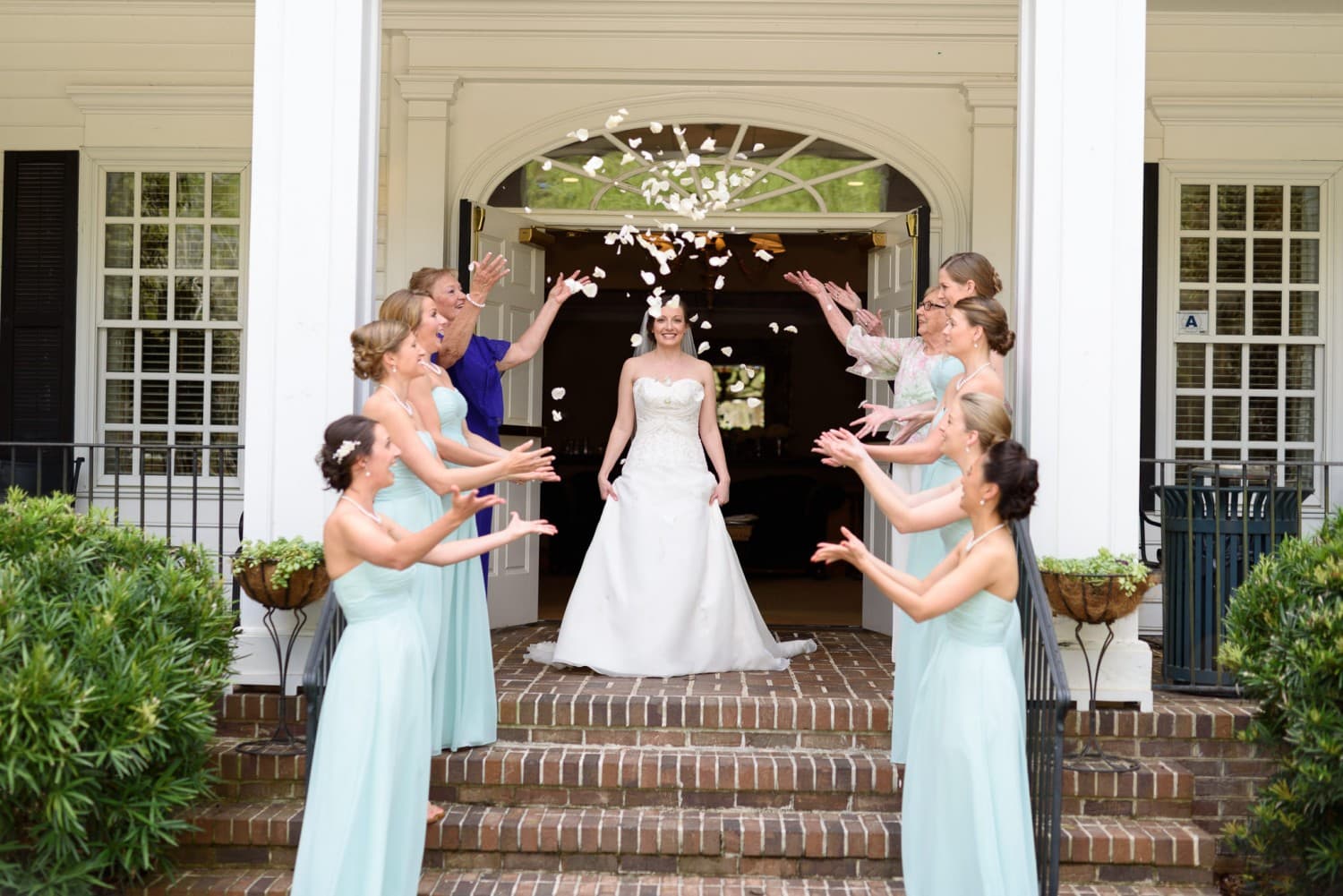 Bridesmaids throwing flower pedals over bride - Pawleys Plantation