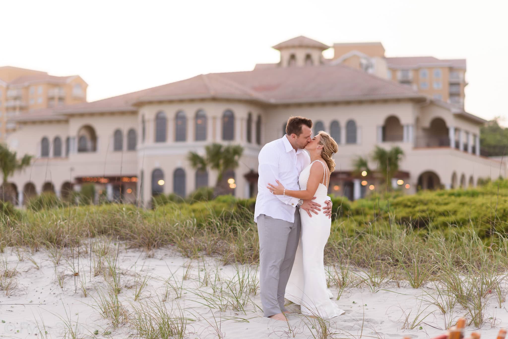 Clubhouse in background of couple kissing - Grande Dunes Ocean Club