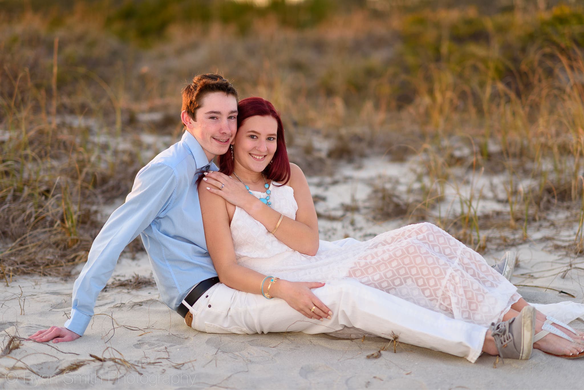 Couple sitting by the dunes showing off the ring - Myrtle Beach State Park