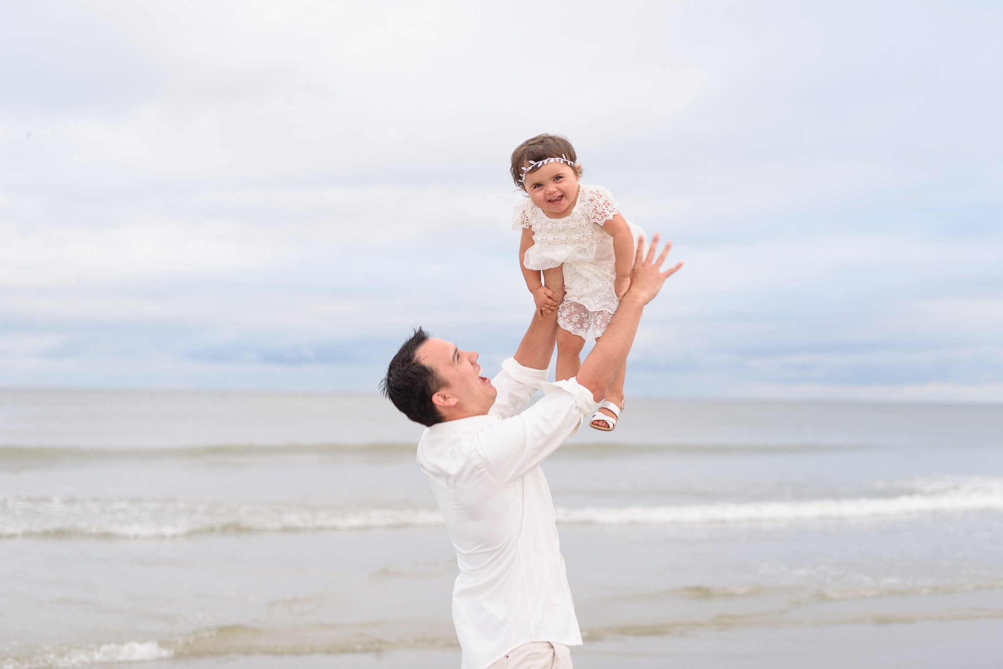 Dad throwing baby girl into the air - North Beach Plantation