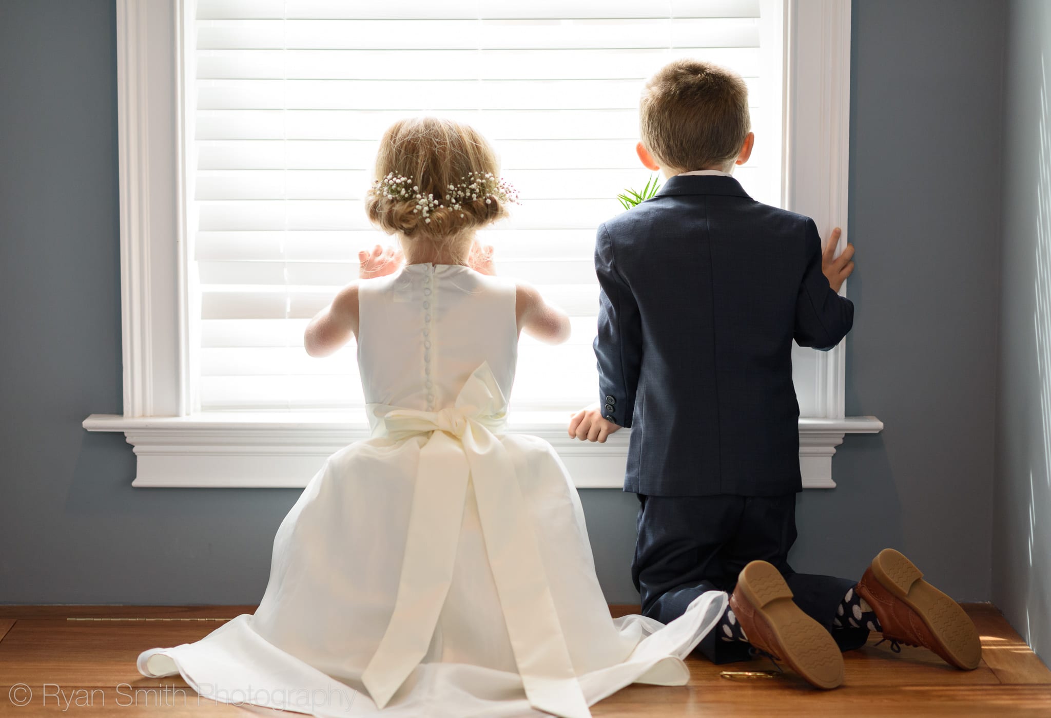 Flower girl and ring bearer watching guests arrive through window - Pawleys Plantation