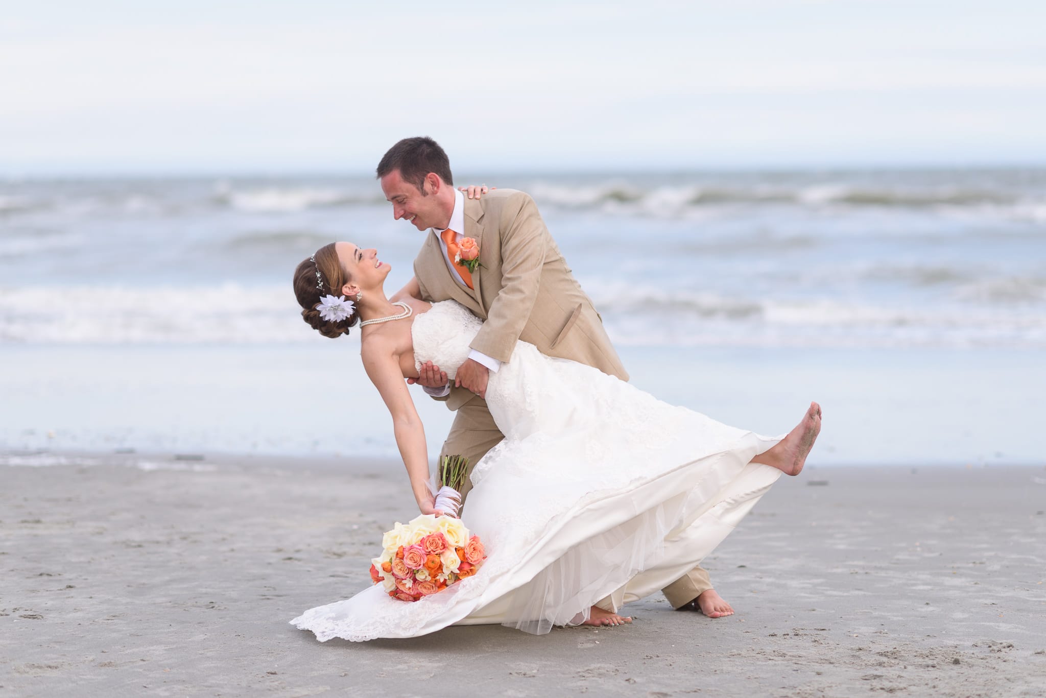 Groom dipping back bride in front of the ocean - Hilton at Kingston Plantation