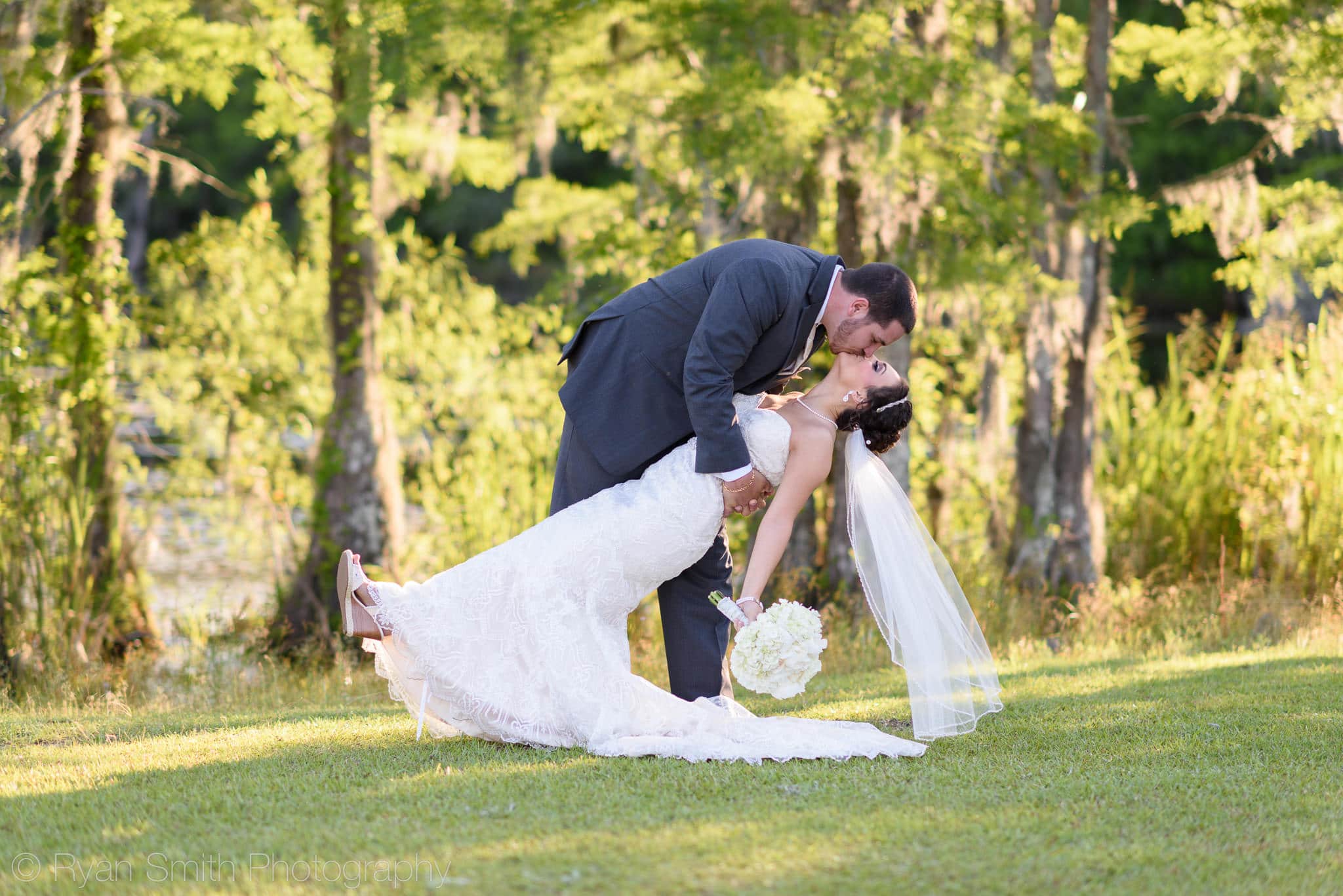 Groom dipping bride back for a kiss - Upper Mill Plantation