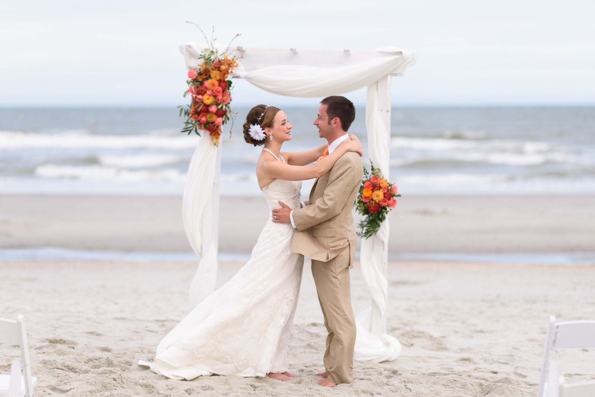 Happy couple in front of beach wedding arbor - Hilton at Kingston Plantation