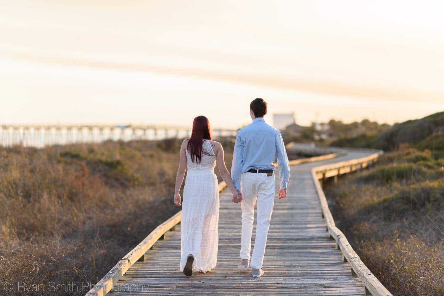 Holding hands walking down the boardwalk together - Myrtle Beach State Park