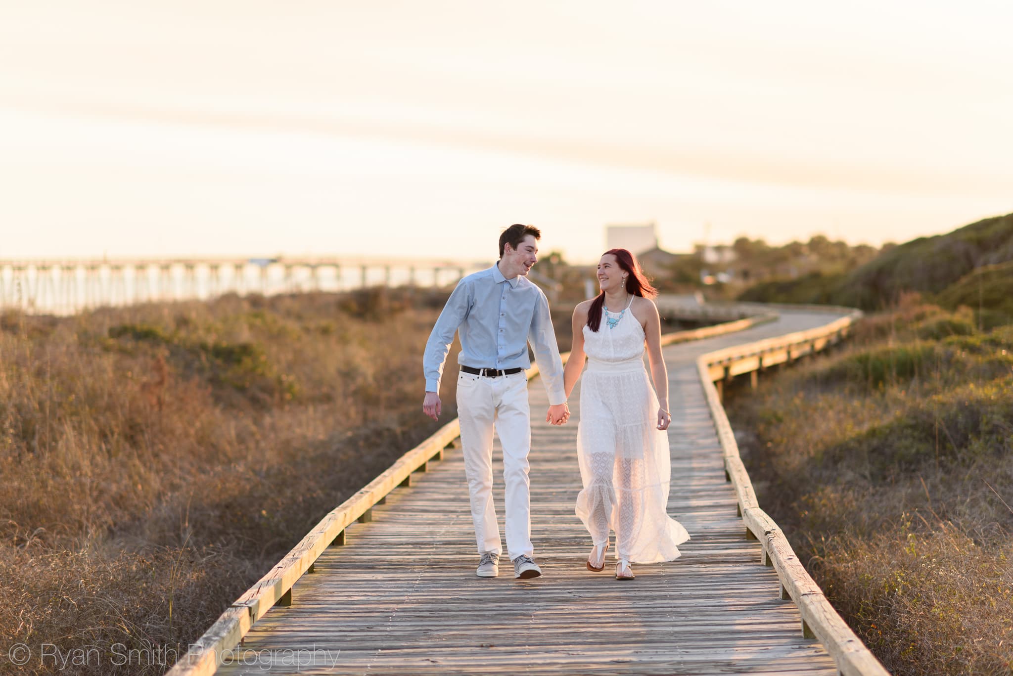 Holding hands walking down the boardwalk together - Myrtle Beach State Park