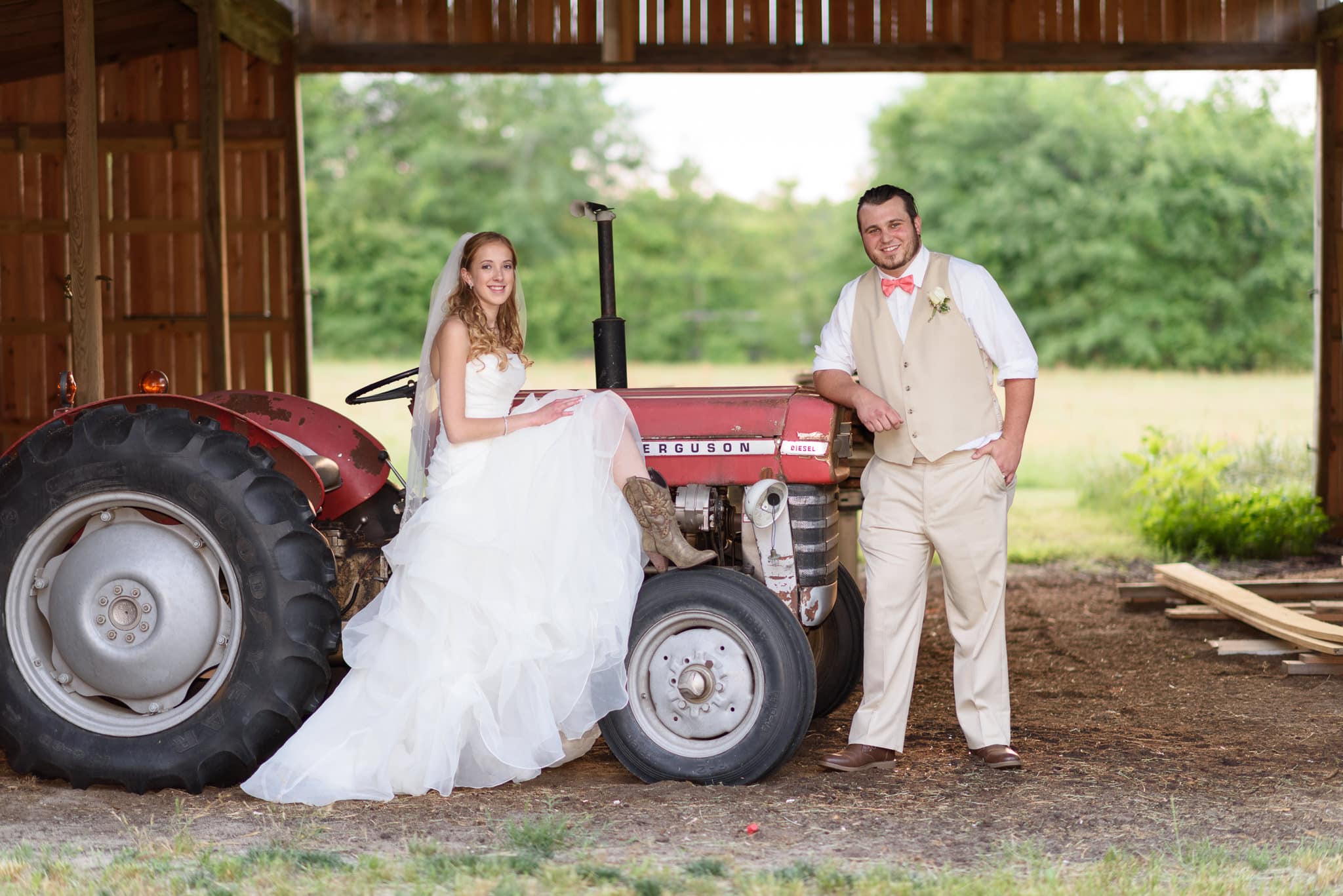 Married couple posing by the red tractor - Wildberry Farm