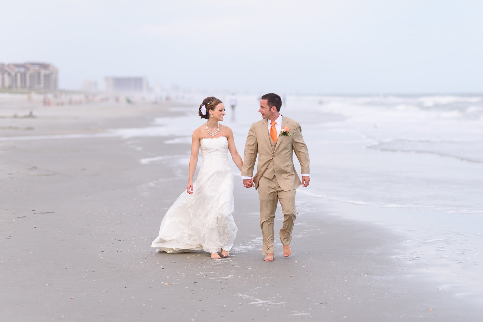 Married couple walking down the beach holding hands - Hilton at Kingston Plantation