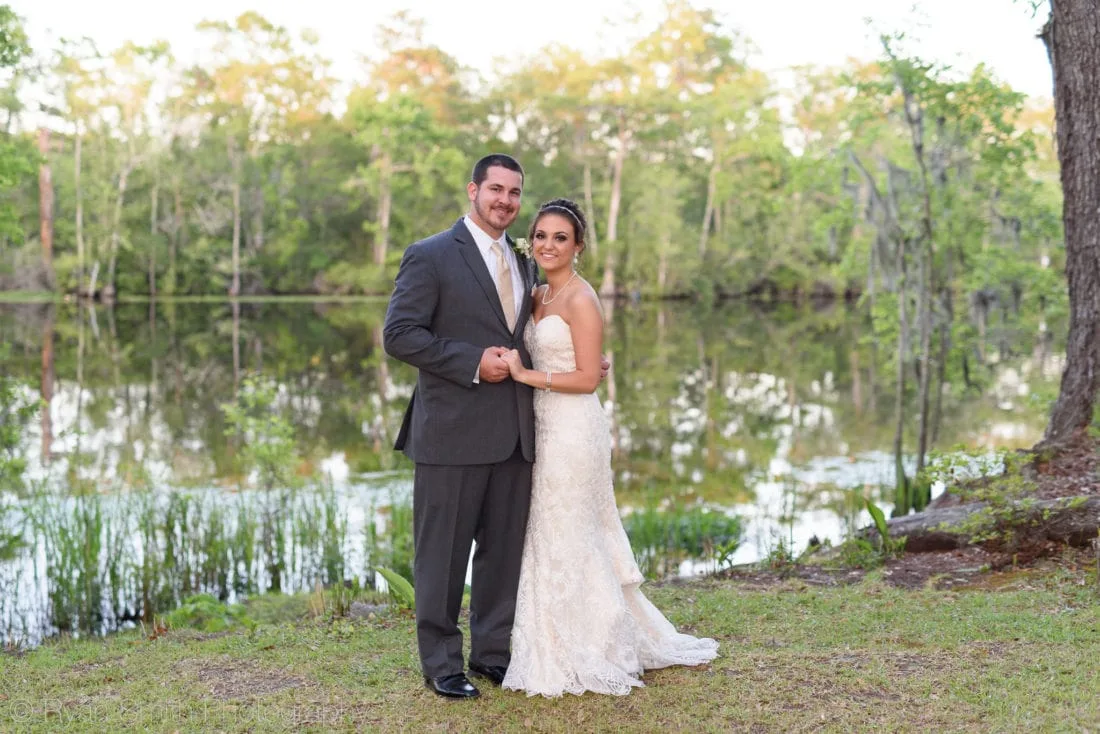 Bride and groom pose at sunset by the Waccamaw River at Upper Mill Plantation